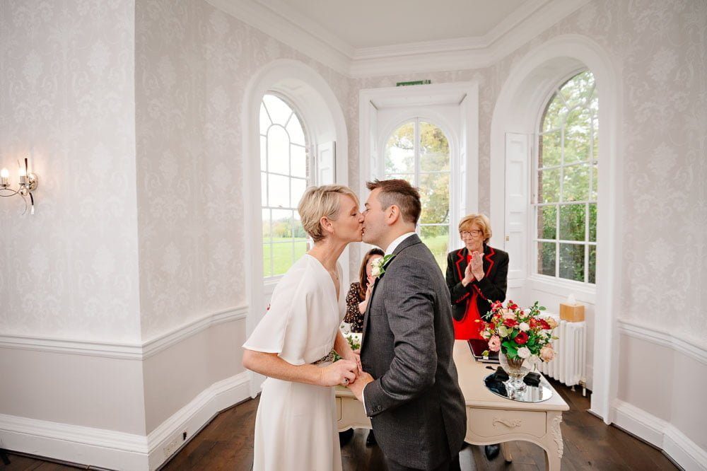 Bride and Groom kiss for the first time at wedding in Morden Park House