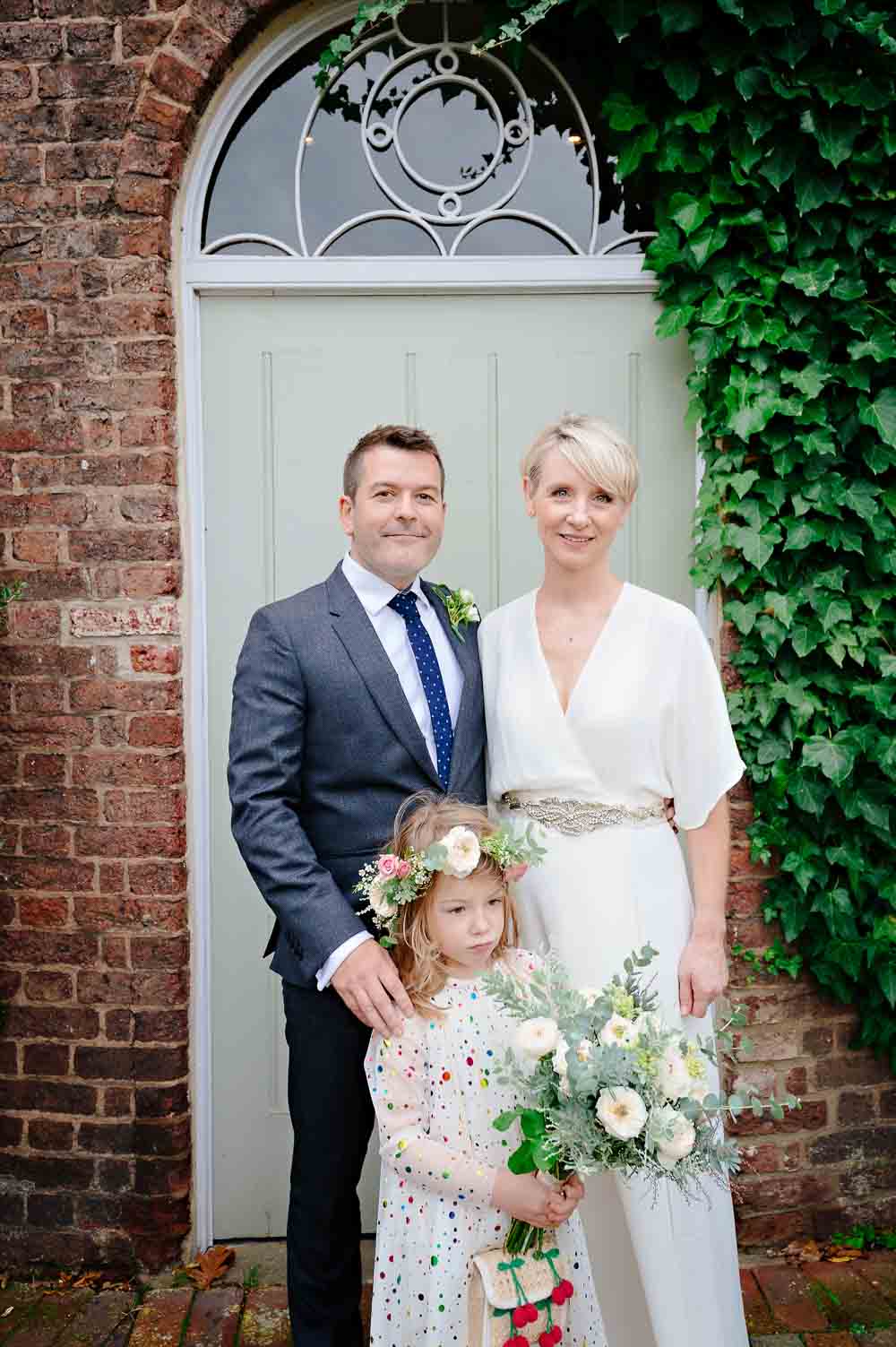 Family wedding portrait of couple with daughter