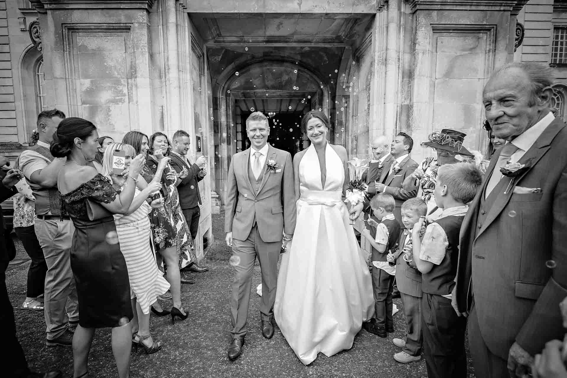 Bride and groom Smiling Amongst Guests at Wedding in Cardiff