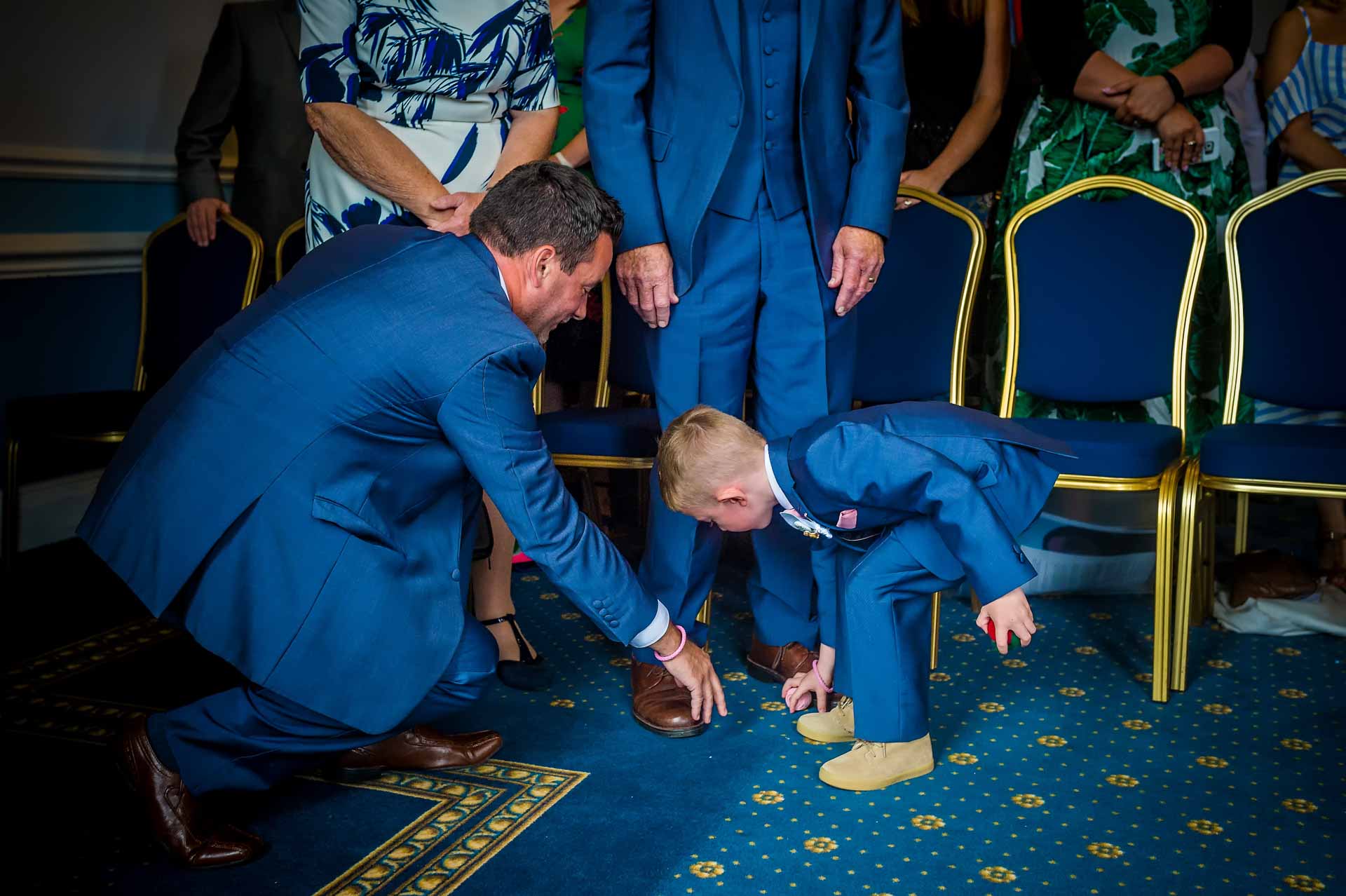 Boy and man picking up dropped rings in Cardiff City Hall wedding