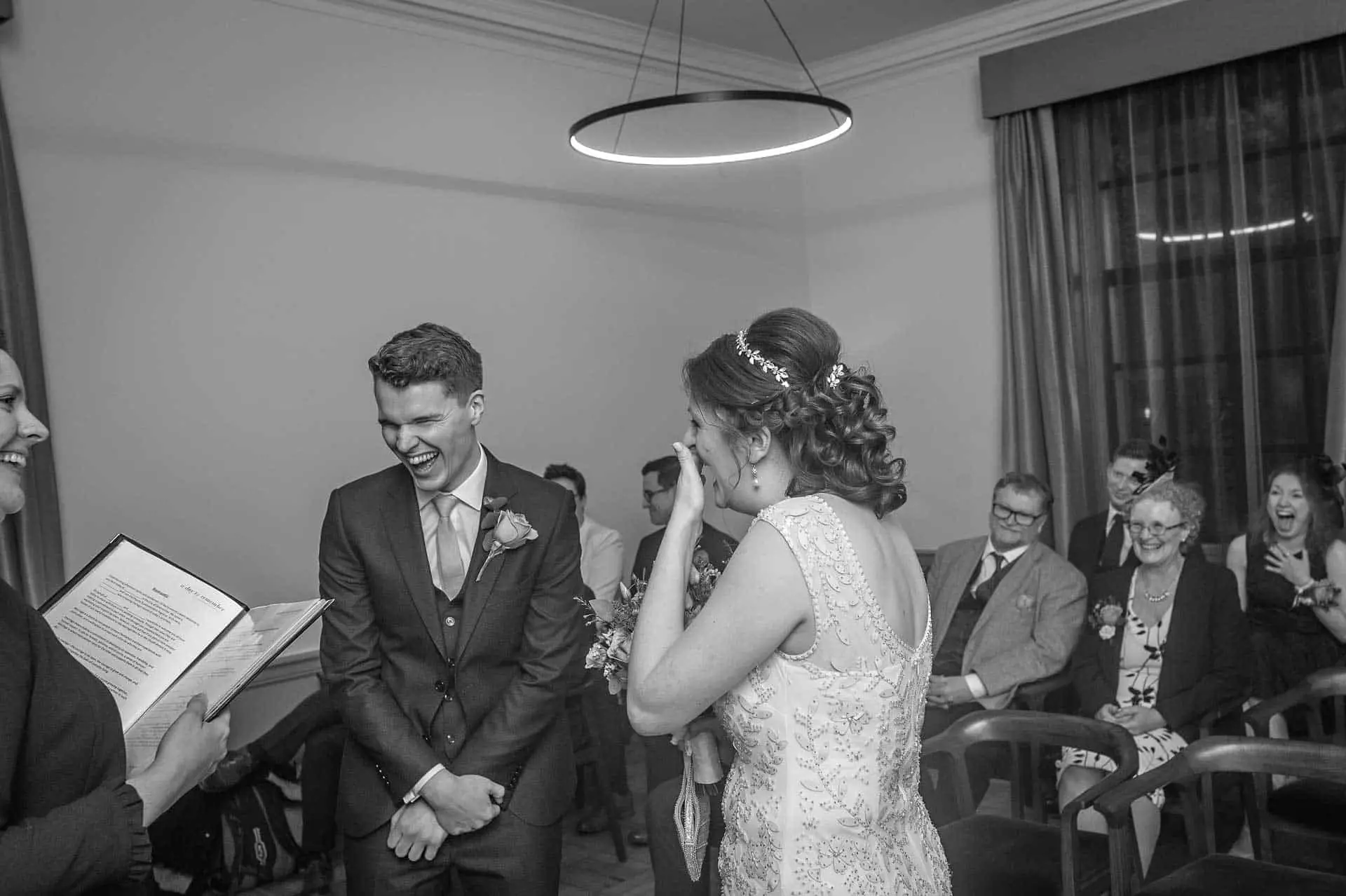 brud og brudgom griner ved bryllup i Det Gamle Marylebone Rådhus