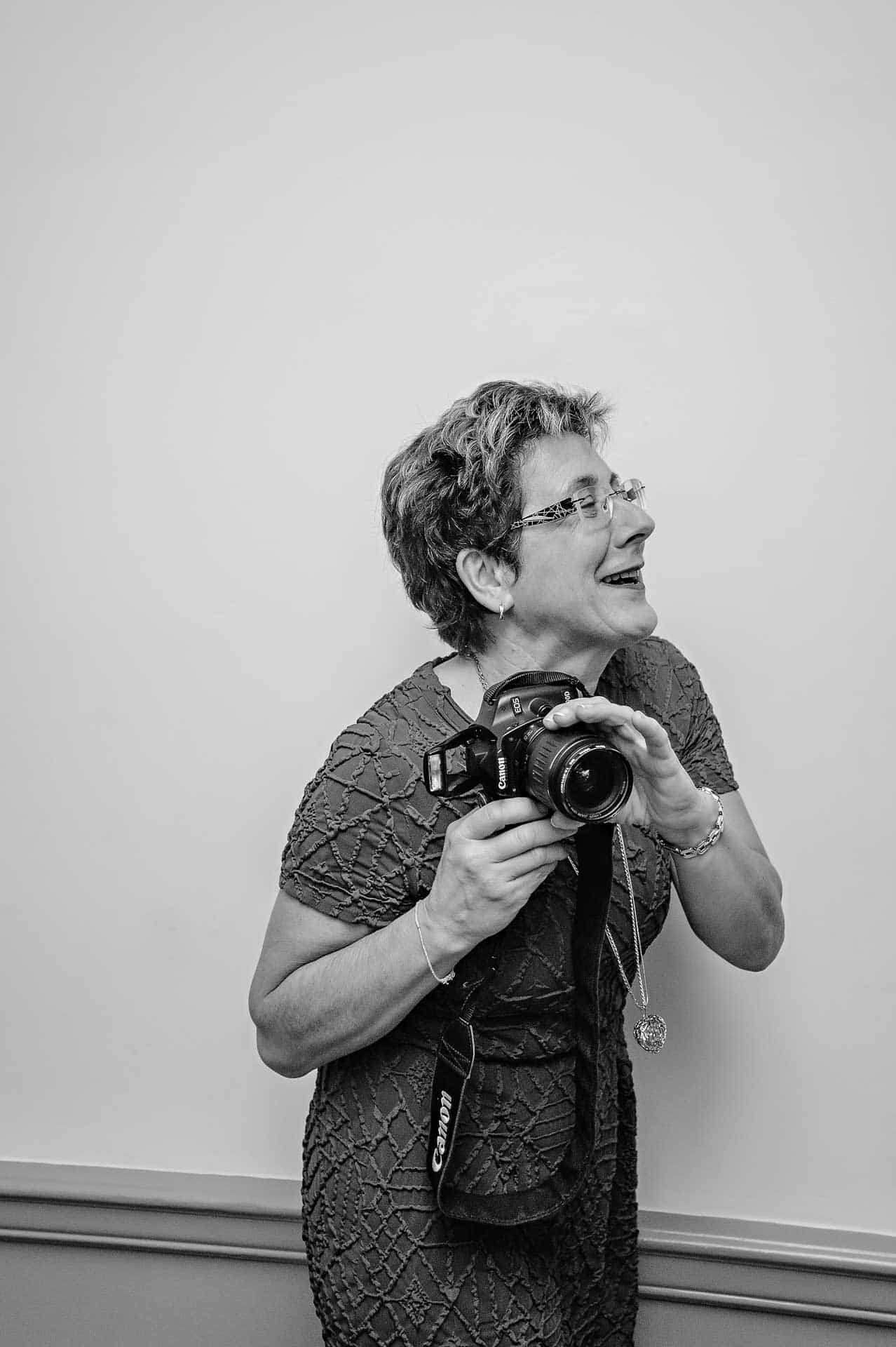 Woman with camera turning away and laughing