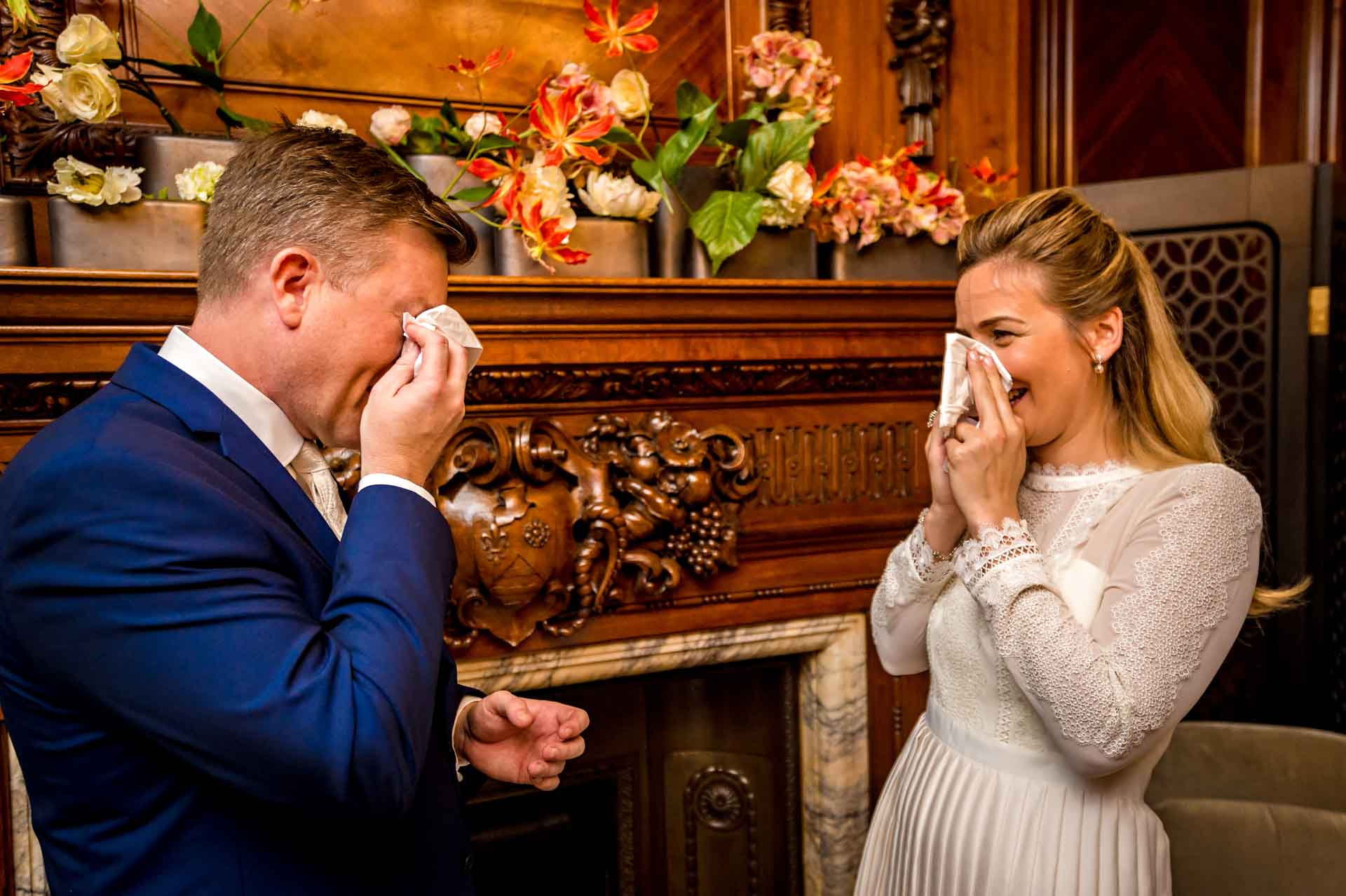 Bride and groom with hankies crying at wedding