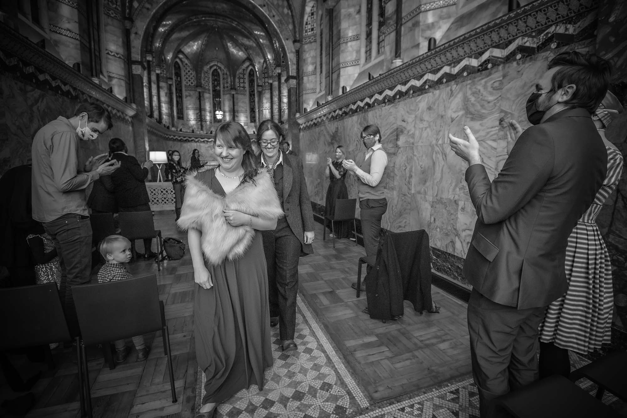 The brides walk back down the Fitzrovia Chapel aisle at their coronavirus restricted wedding