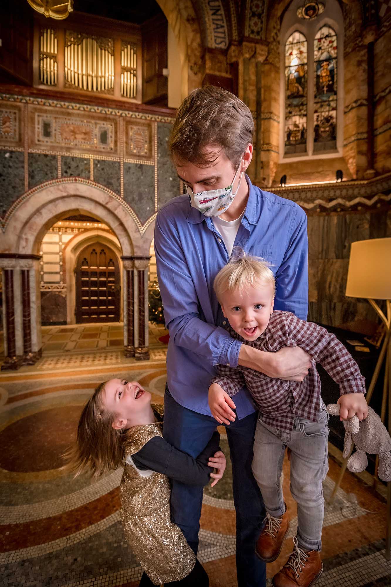Covid-19 masked father playing with son and daughter at wedding in Fitzrovia Chapel