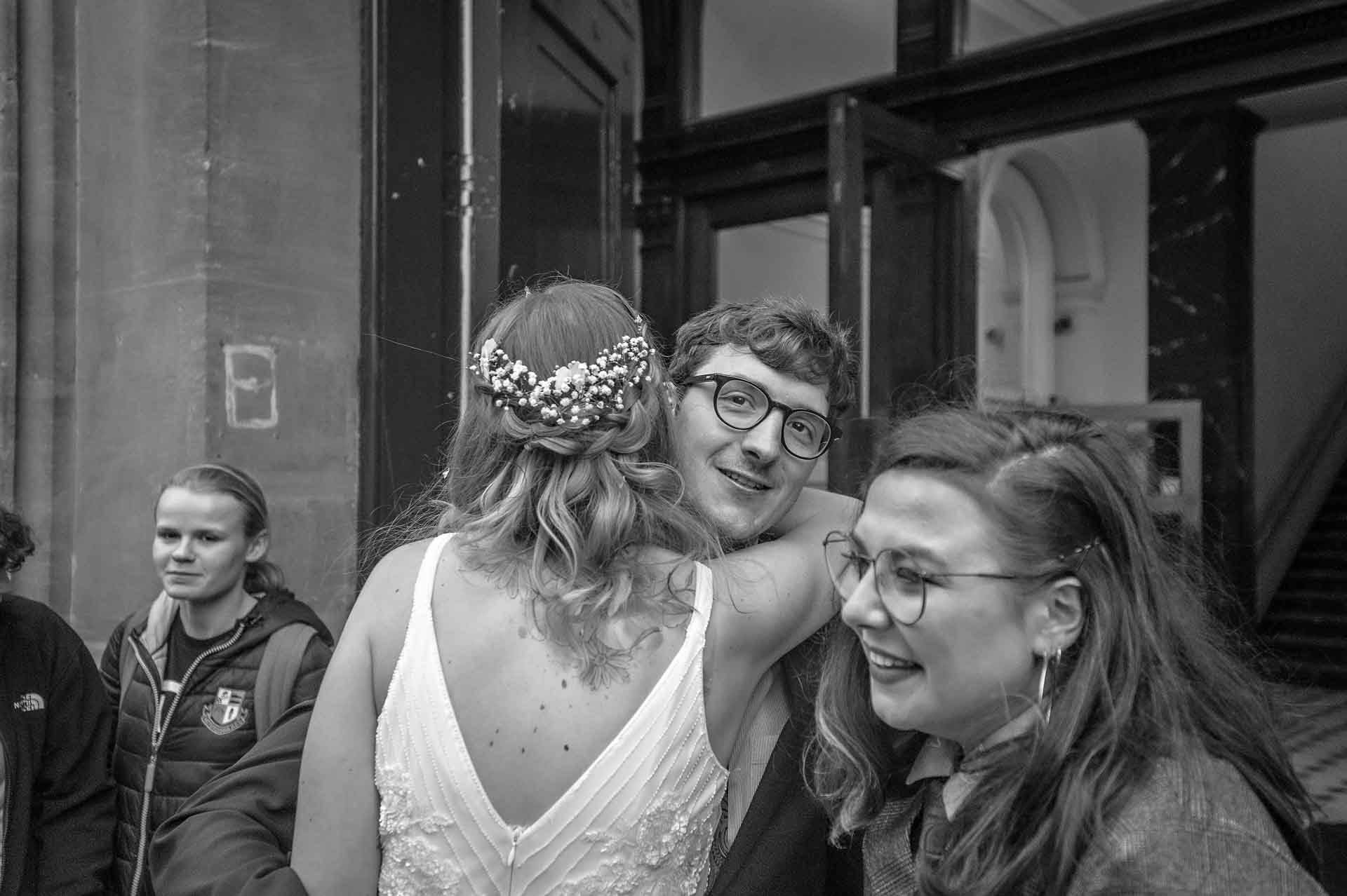 Bespectacled guest being hugged by bride at wedding in Bristol