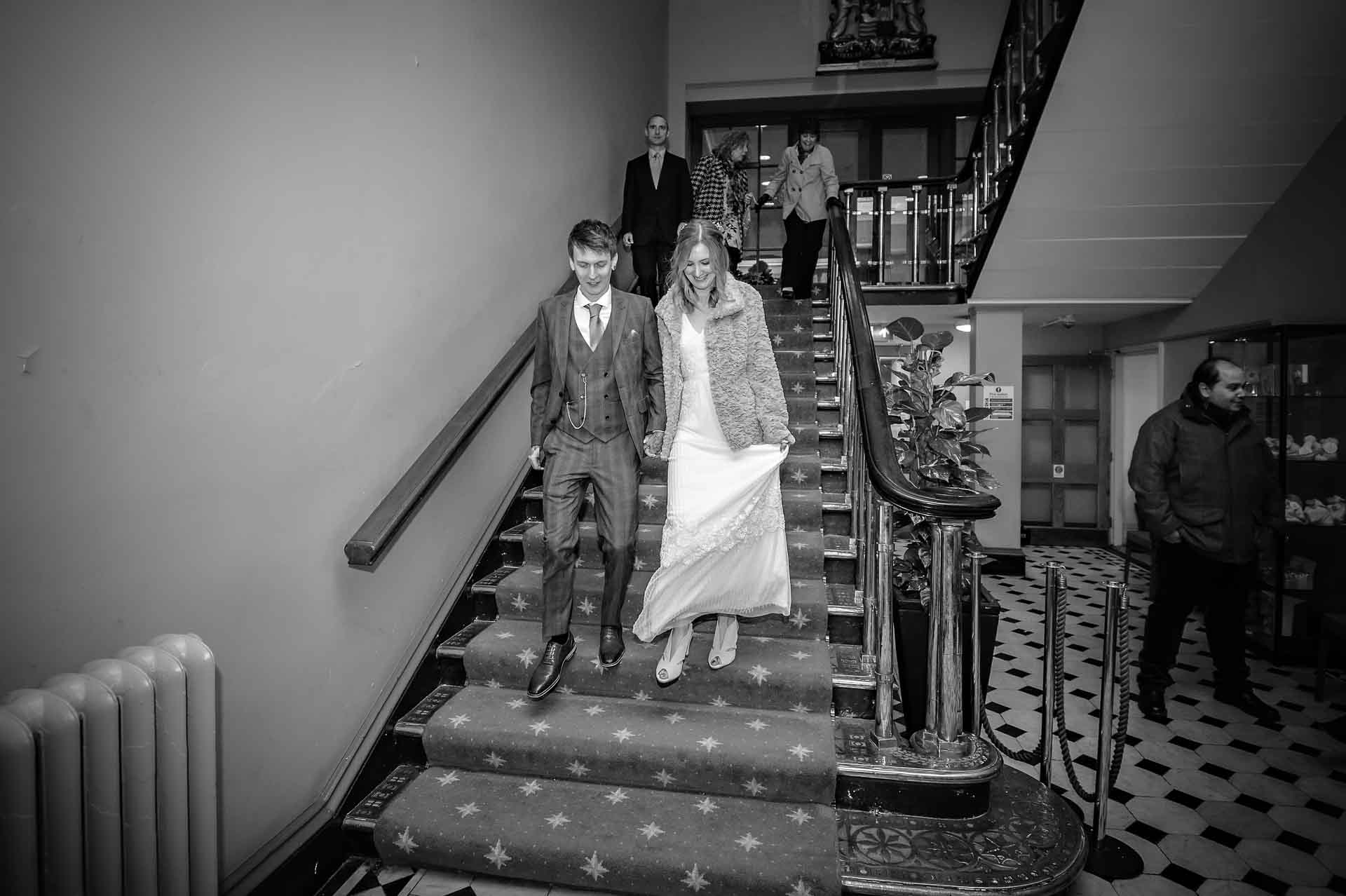 Newly married couple walking down the staircase at Bristol Register Office