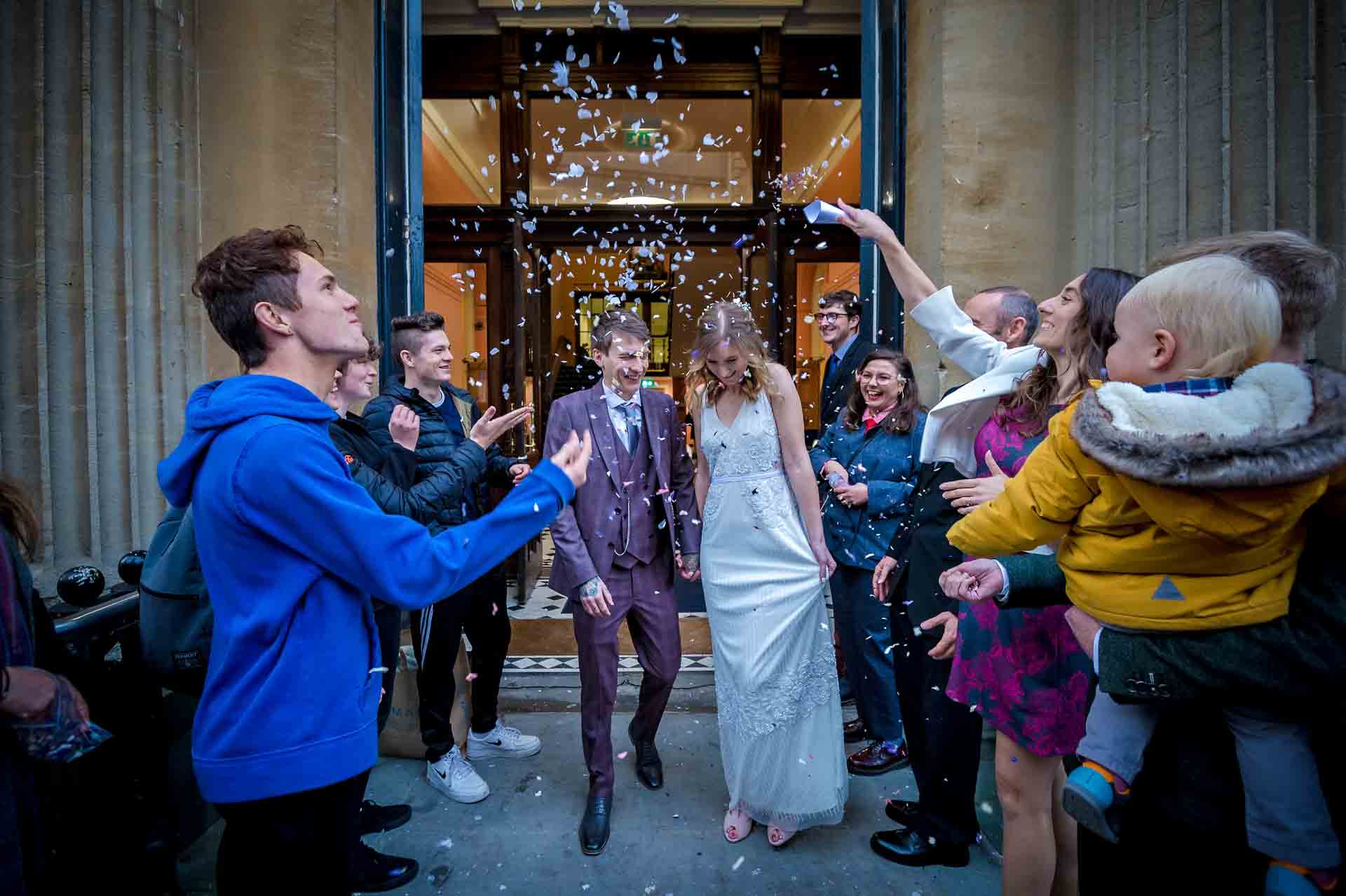Guests throw confetti over the couple at Bristol Register Office