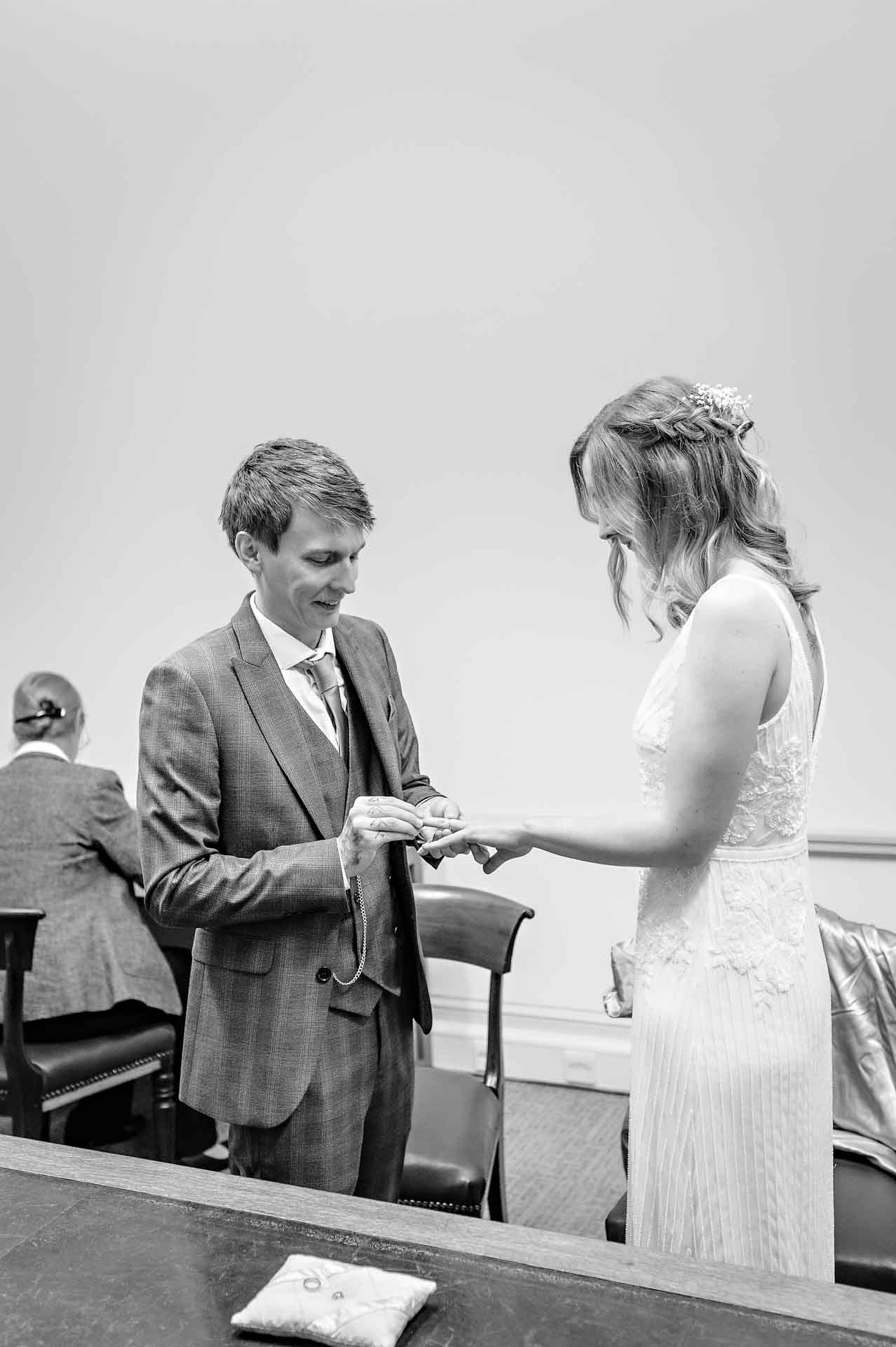 The groom places the rings on the bride's finger in the Statutory Room at the Old Council House in Bristol