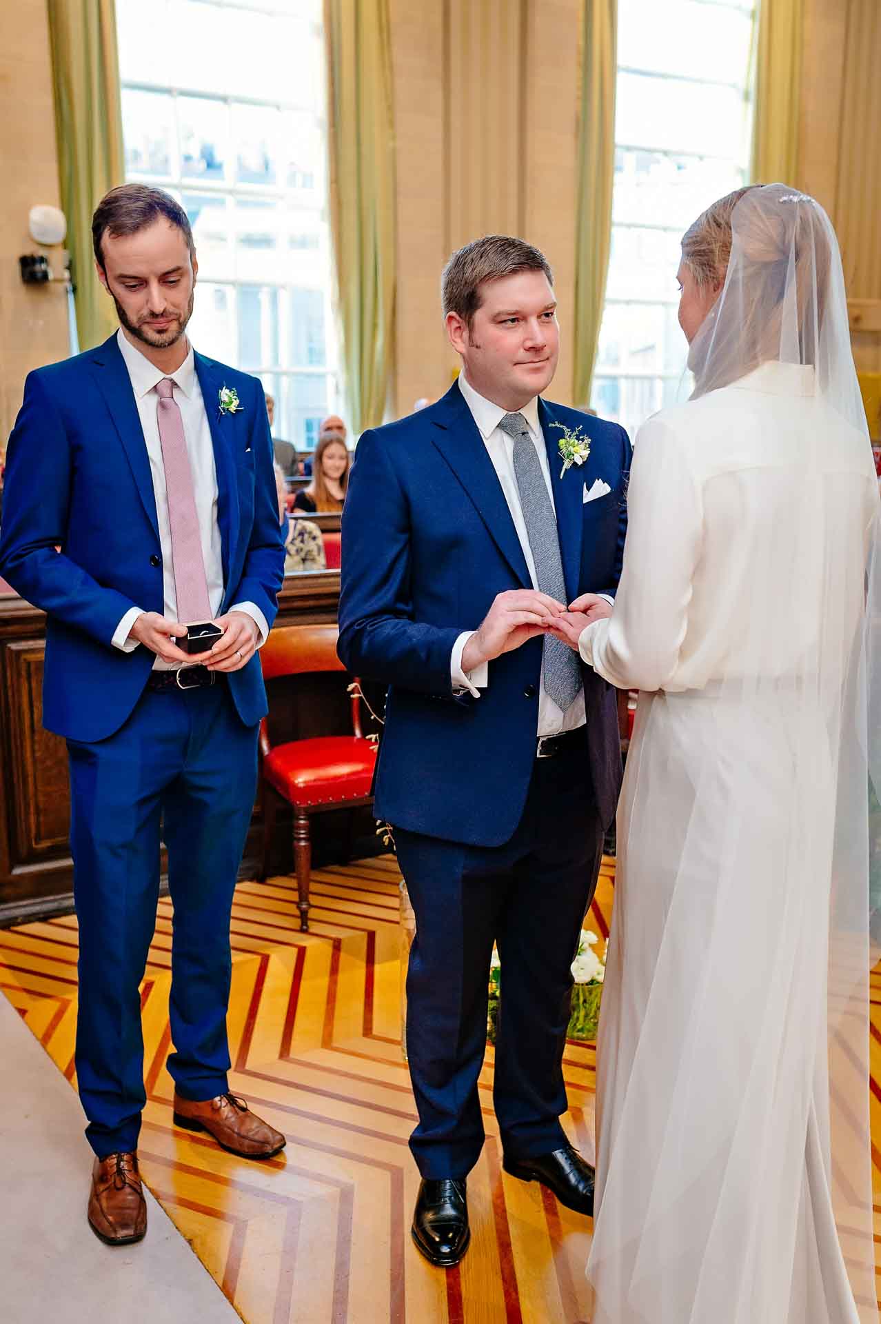 The groom places ring on finger of bride in Bristol