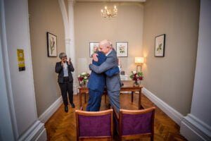 The newlyweds hug in the small Harrington Room in Chelsea
