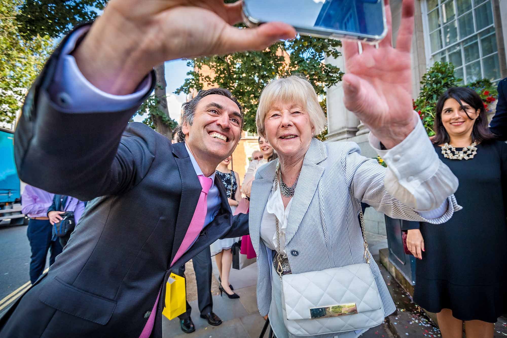 Two wedding guests taking a selfie at a wedding in London