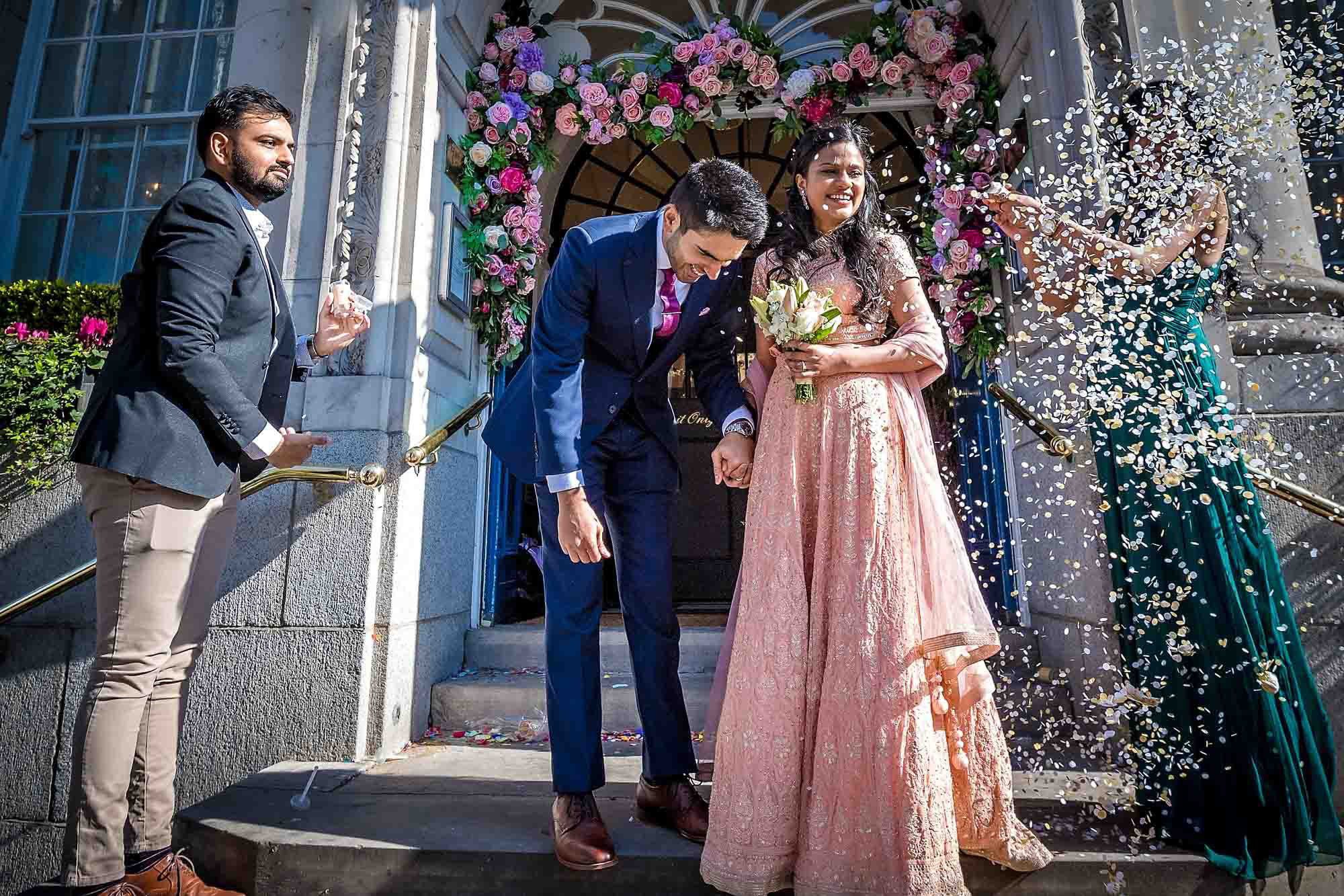 A bridesmaid getting covered with confetti due to the high windin Chelsea