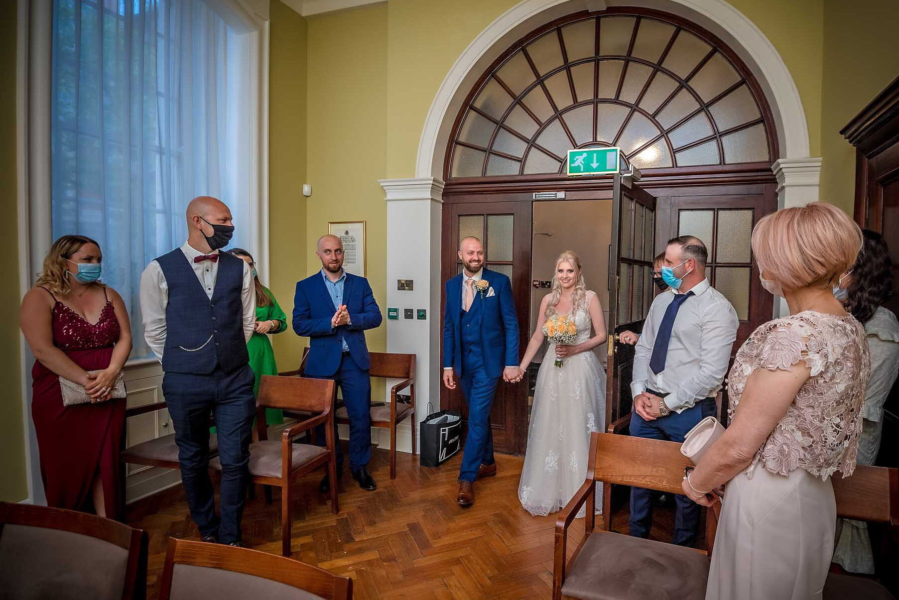 The couple enter the Rossetti Room in Chelsea for their wedding ceremony as guests look on