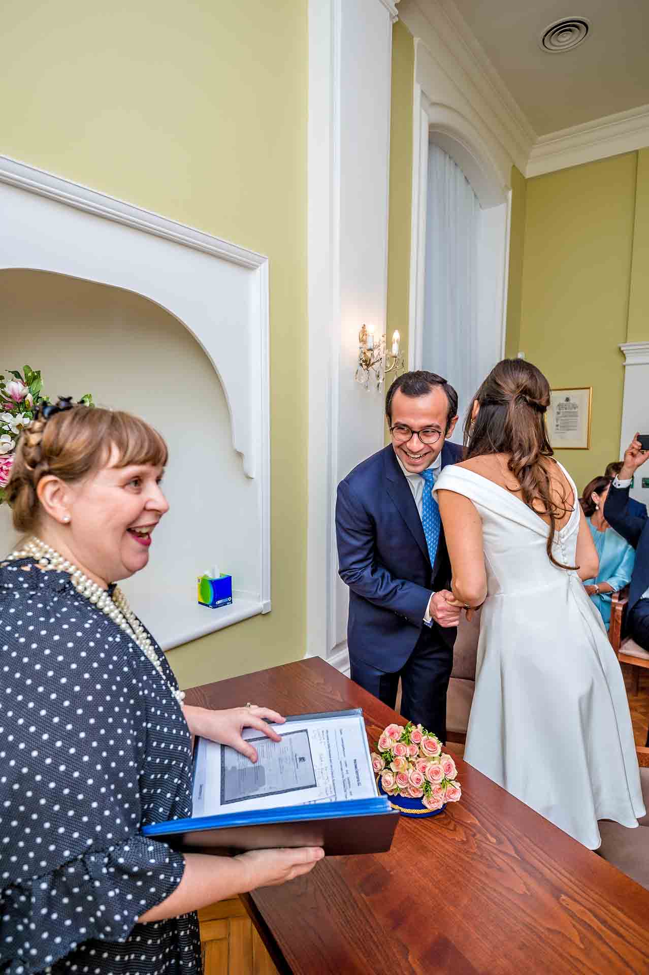 Couple Laughing with registrar at London wedding