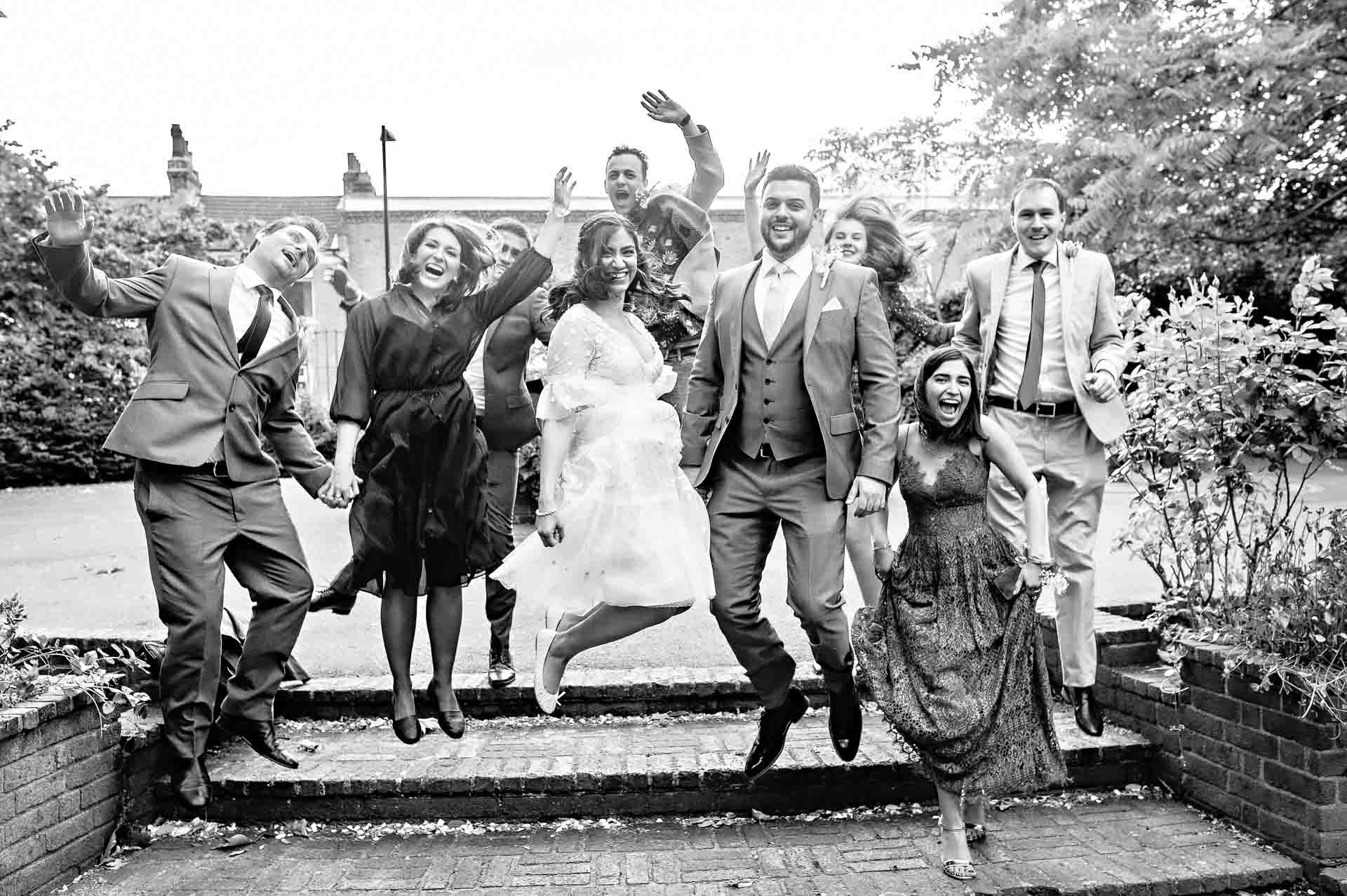Family jumping off step at wedding in Lucas Garens London