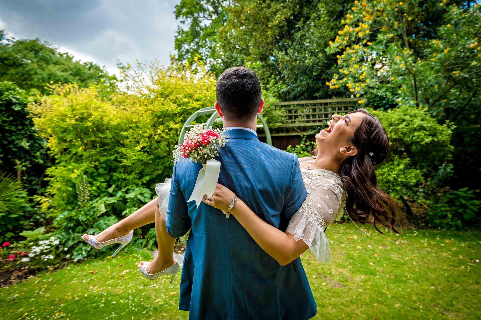 Groom spinning bride around and bride laughing