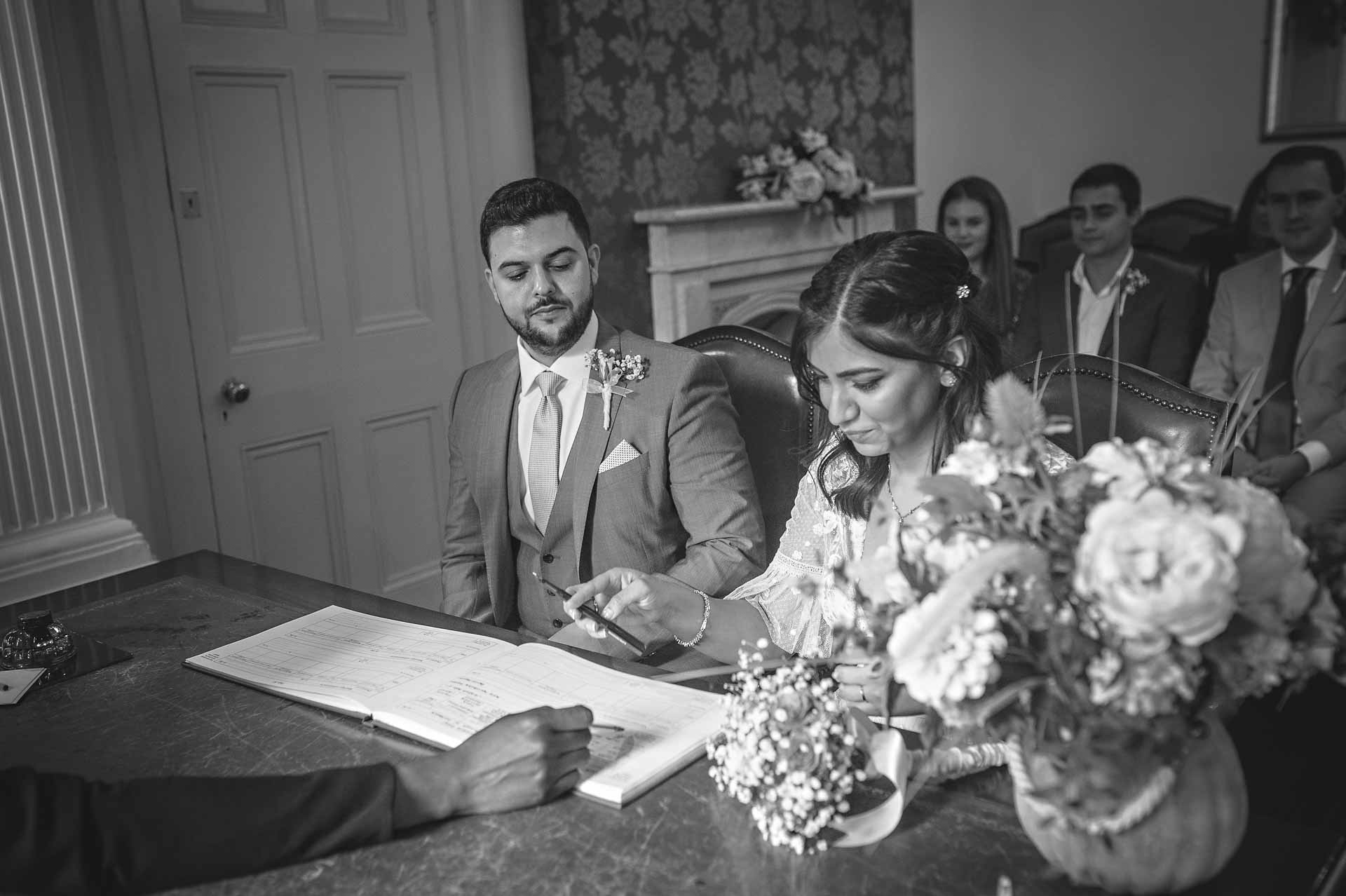Southwark Register Office Wedding - Couple Signing the Register in Black and White