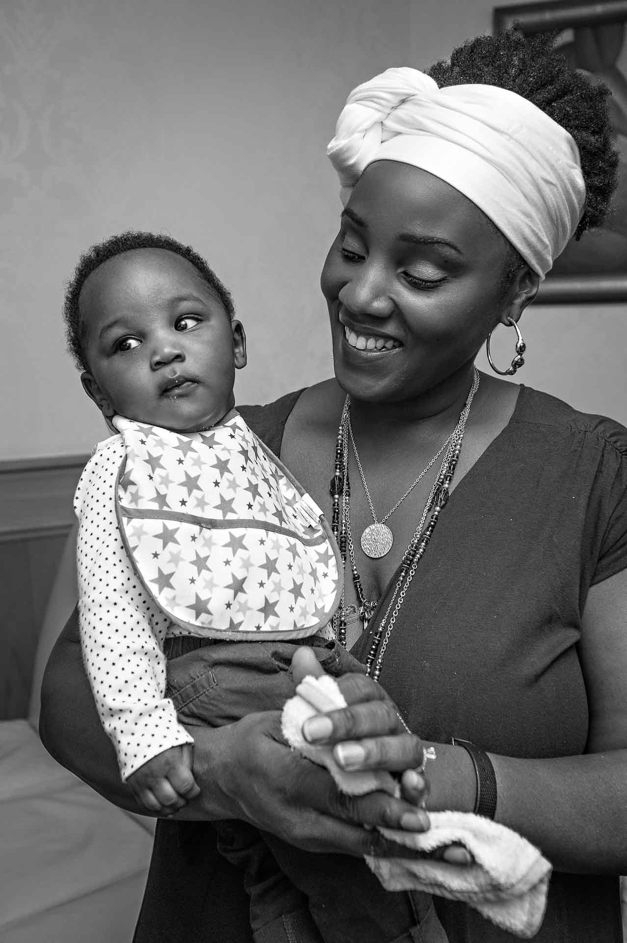 Baby wearing bib with smiling mother at wedding