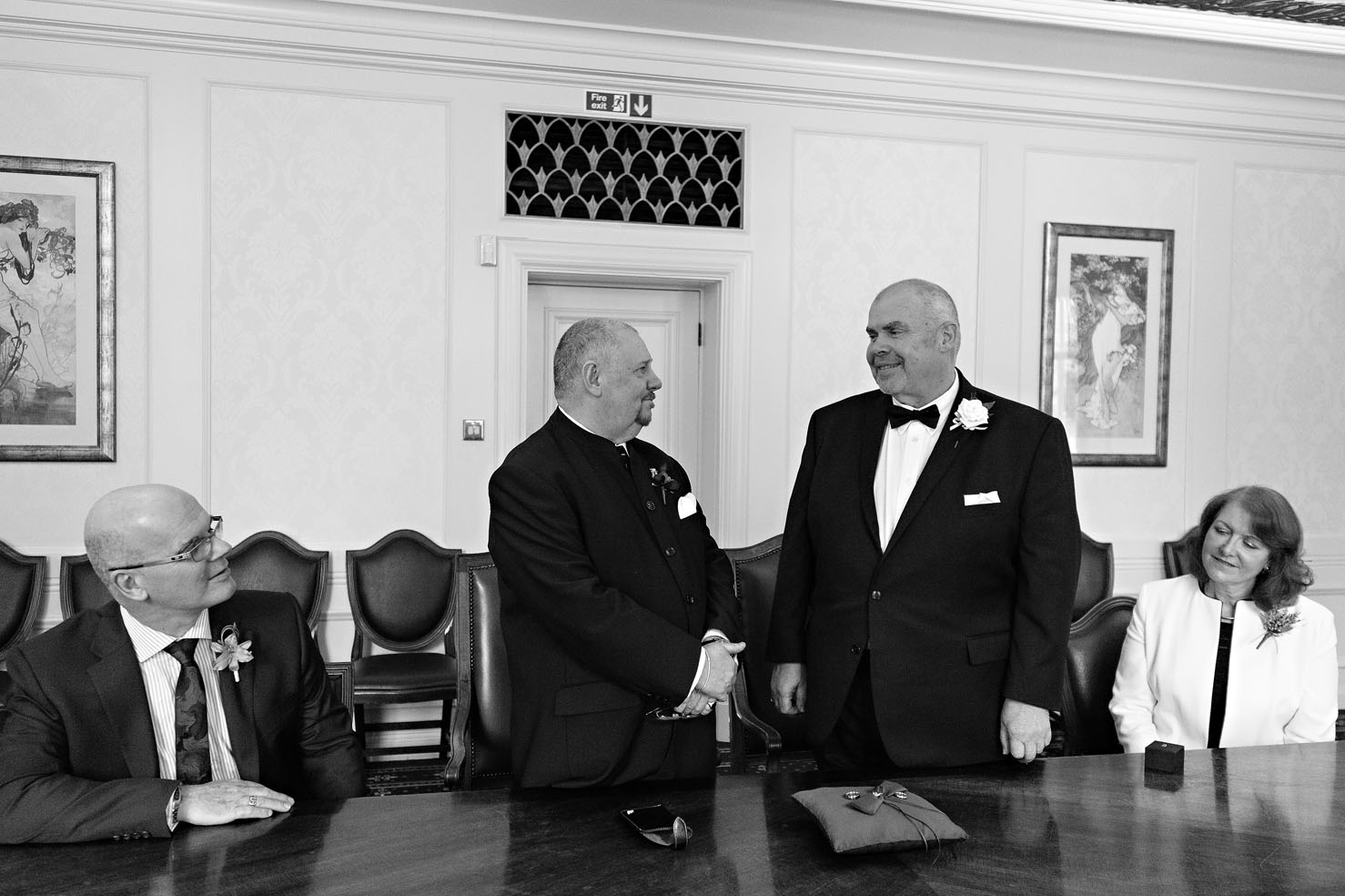 The grooms look at each other in the Victoria Room at a Wandsworth Town Hall gay wedding