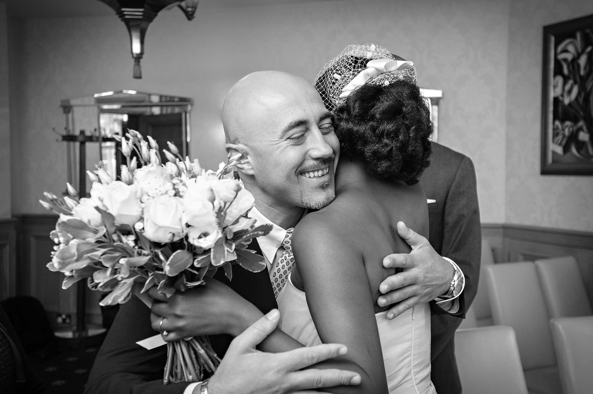 Male family member smiling and hugging bride at Wandsworth Town Hall