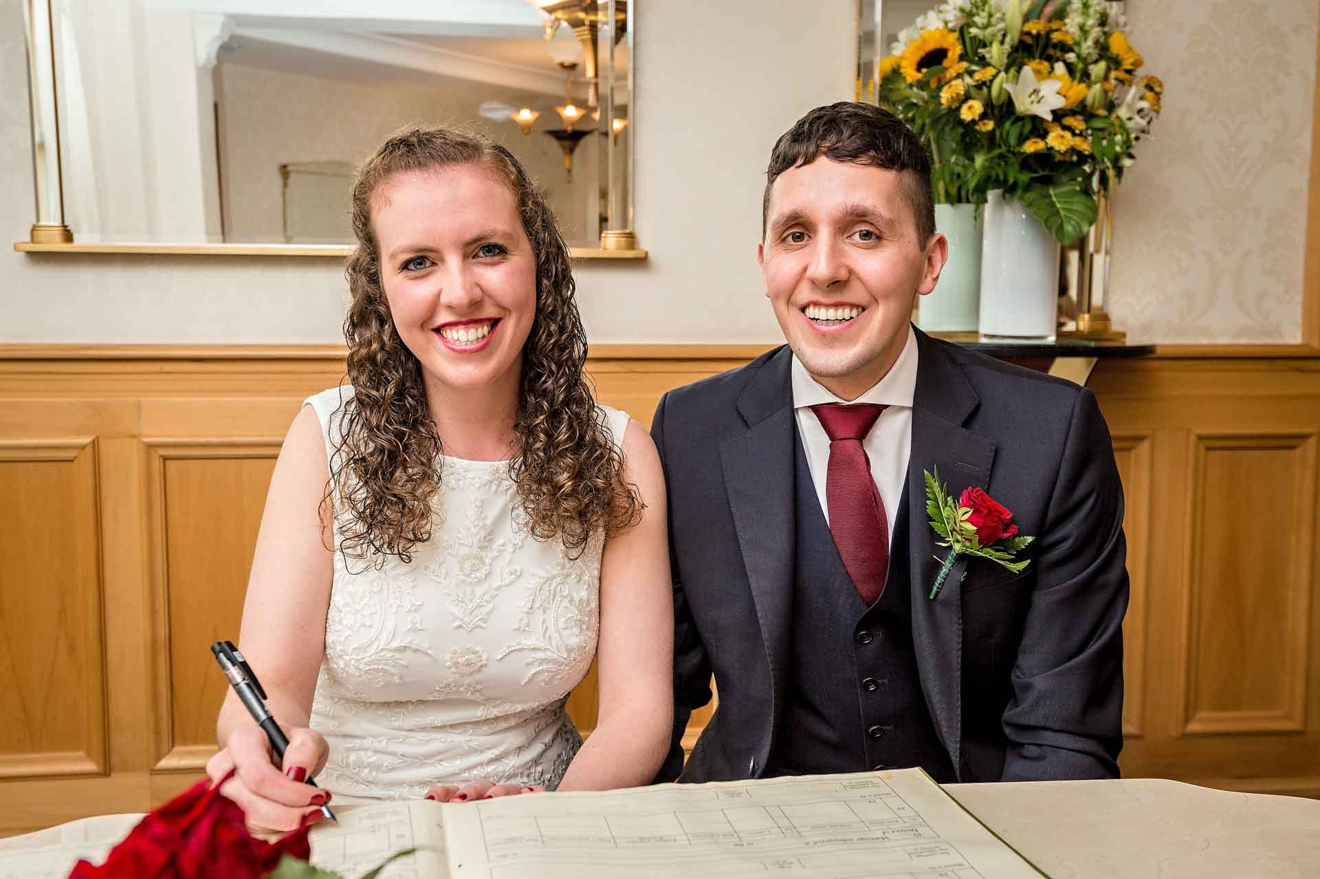 Bride holding pen at dummy register signing in Wandsworth Register Office