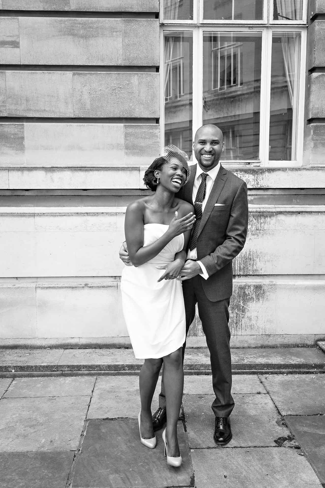 Bride and Groom laughing whilst posing for wedding portrait