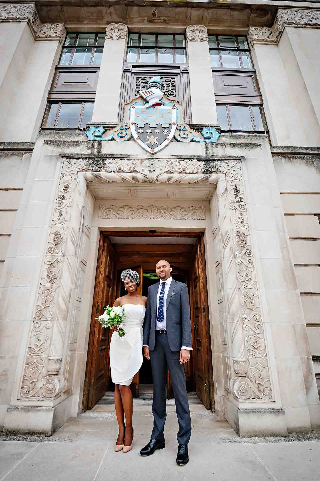 The happy couple standing outside the front door of Wandsworth Town Hall