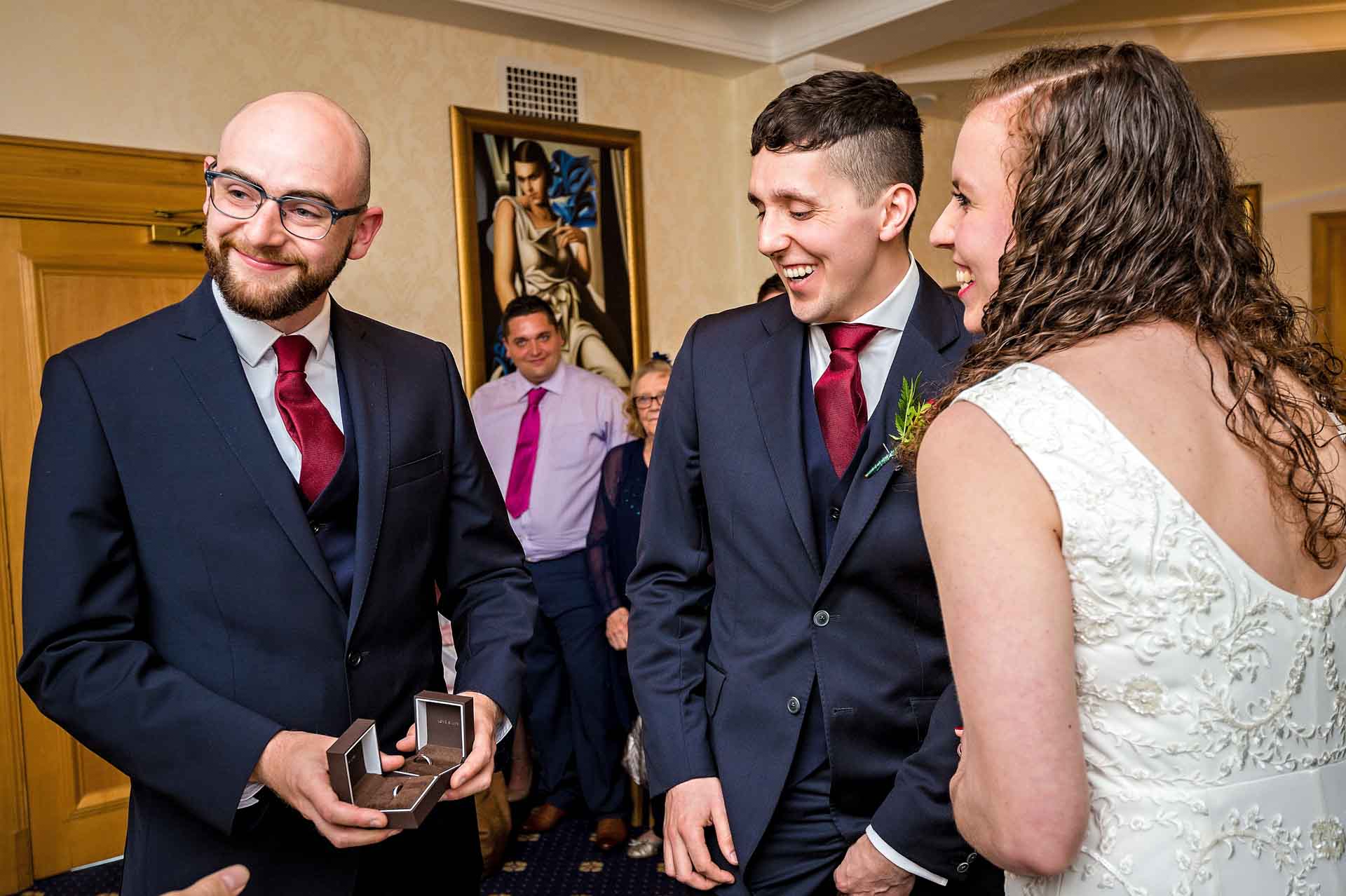 Smiling best man with couple holding rings at Wandsworth Town Hall wedding