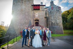 The wedding party of seven pose as the sun disappears behind Castell Coch