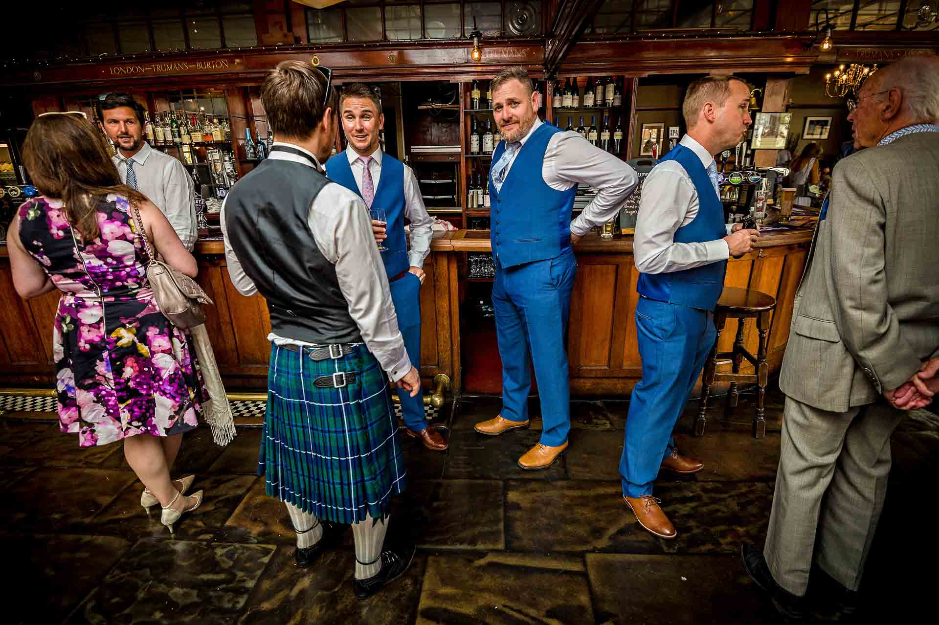 Groomsmen and wedding guests in pub before wedding