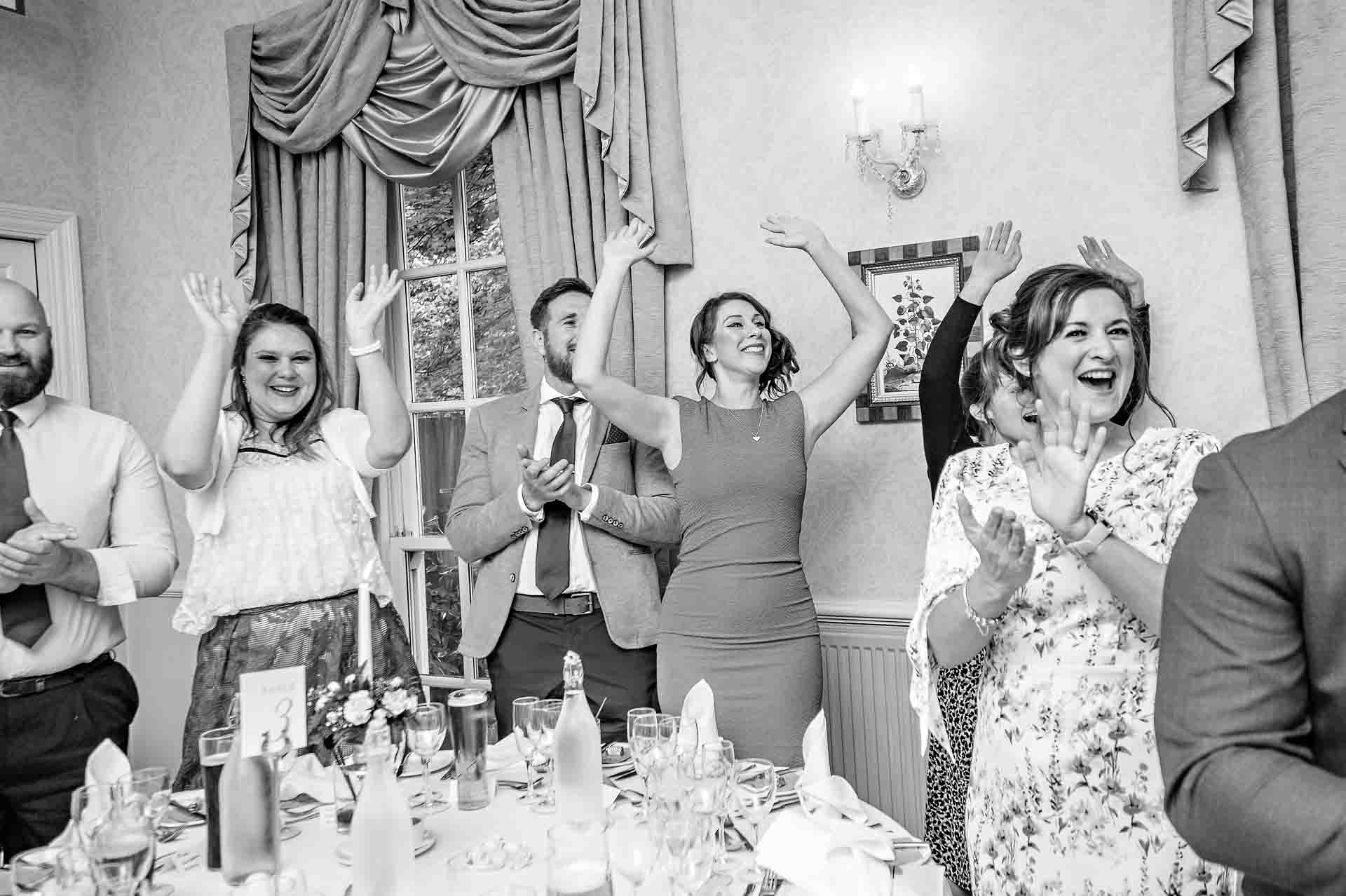 Guests cheering and clapping couple at wedding in Cardiff