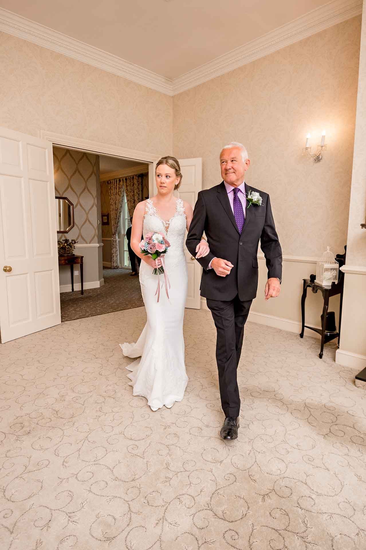 Bride with father walks into ceremony room