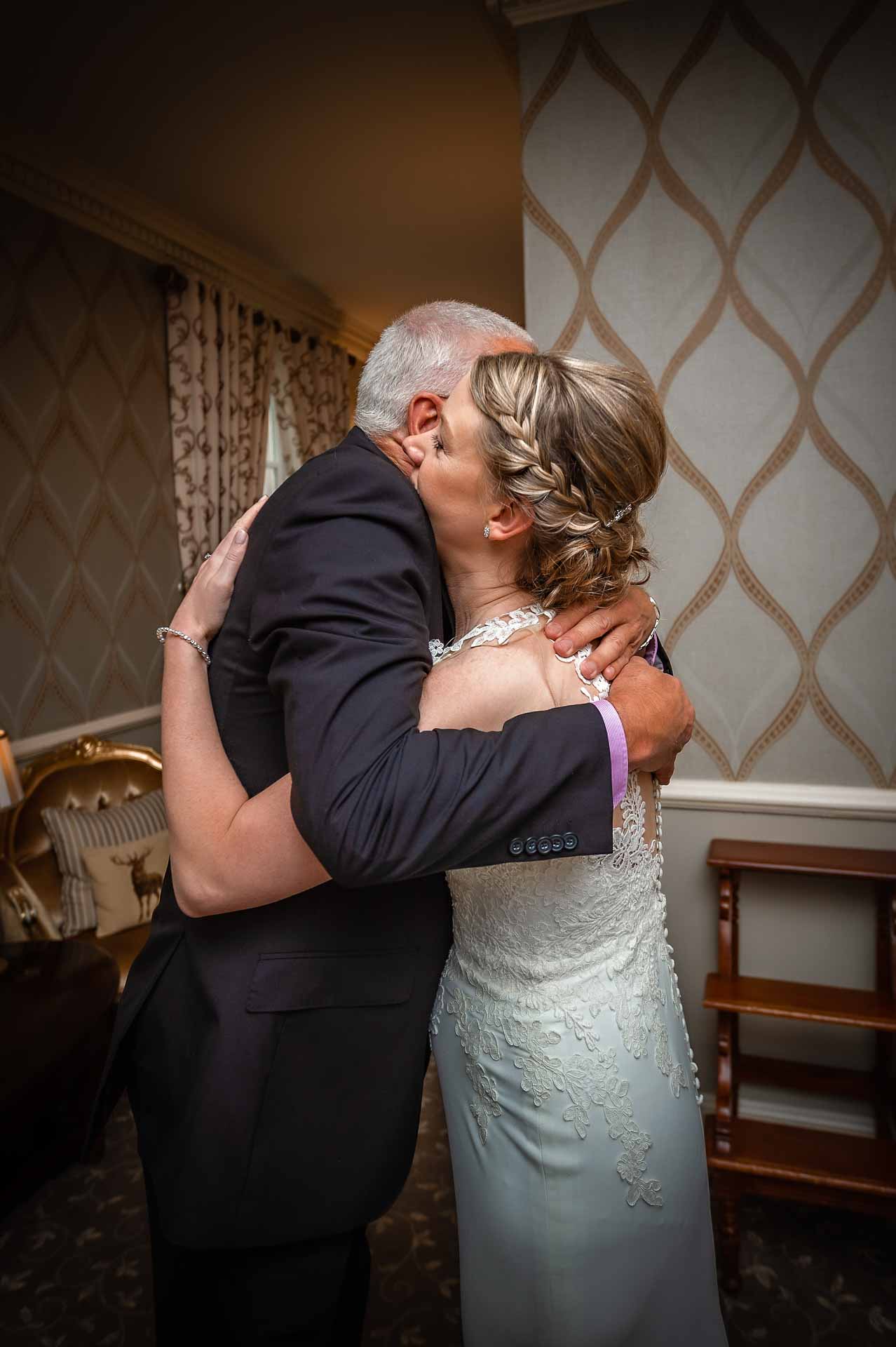 Bride hugging father after wedding reception