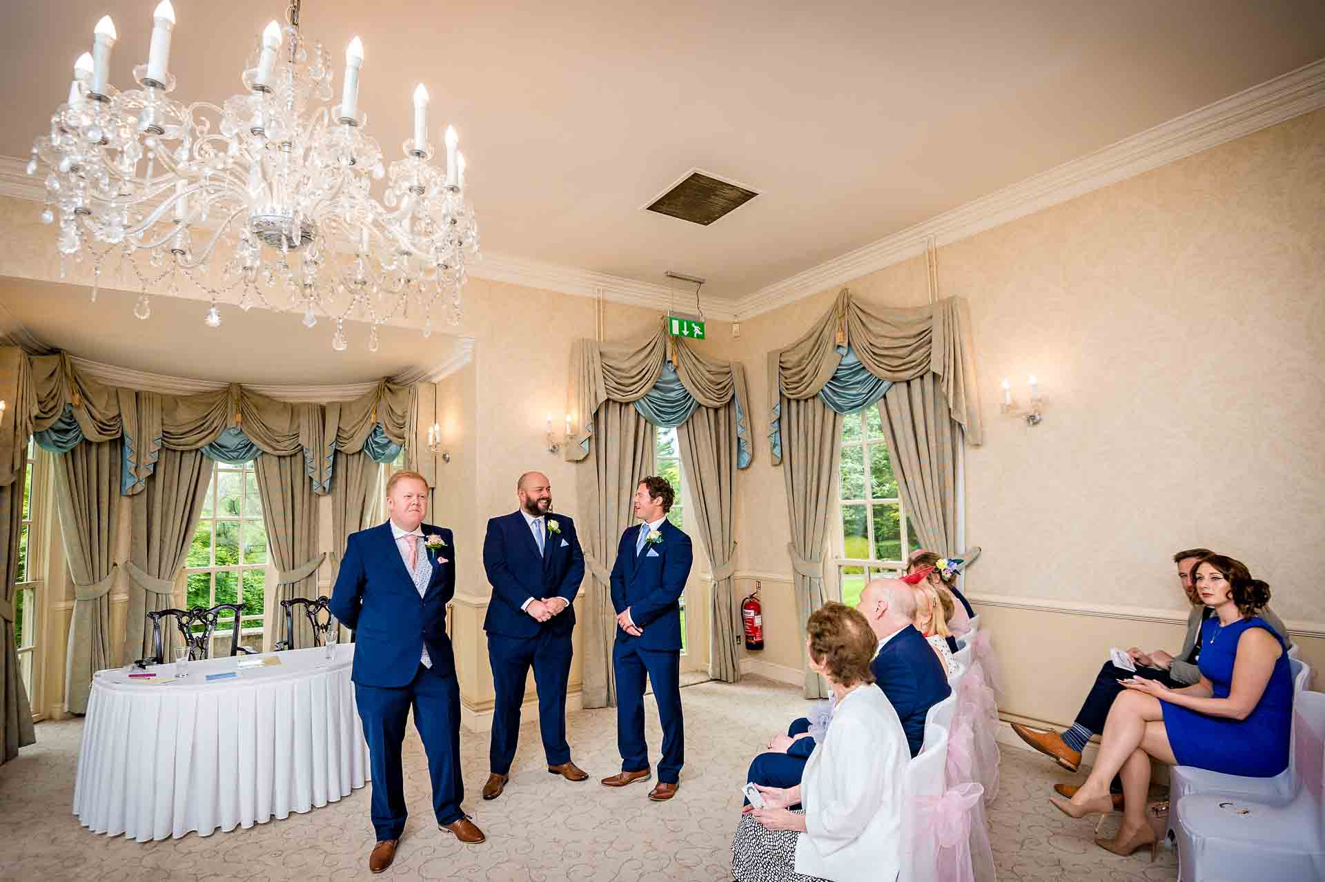 The groom and guests wait in a function suite at DeCourceys Manor near Cardiff