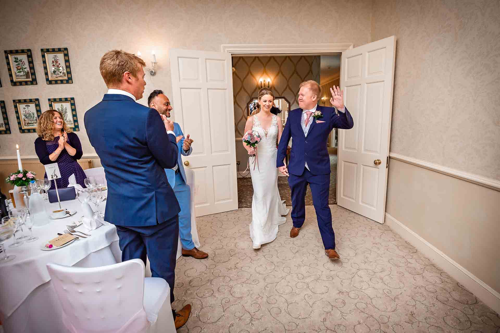 Happy couple walking into the function suite at DeCourceys Manor for their wedding breakfast
