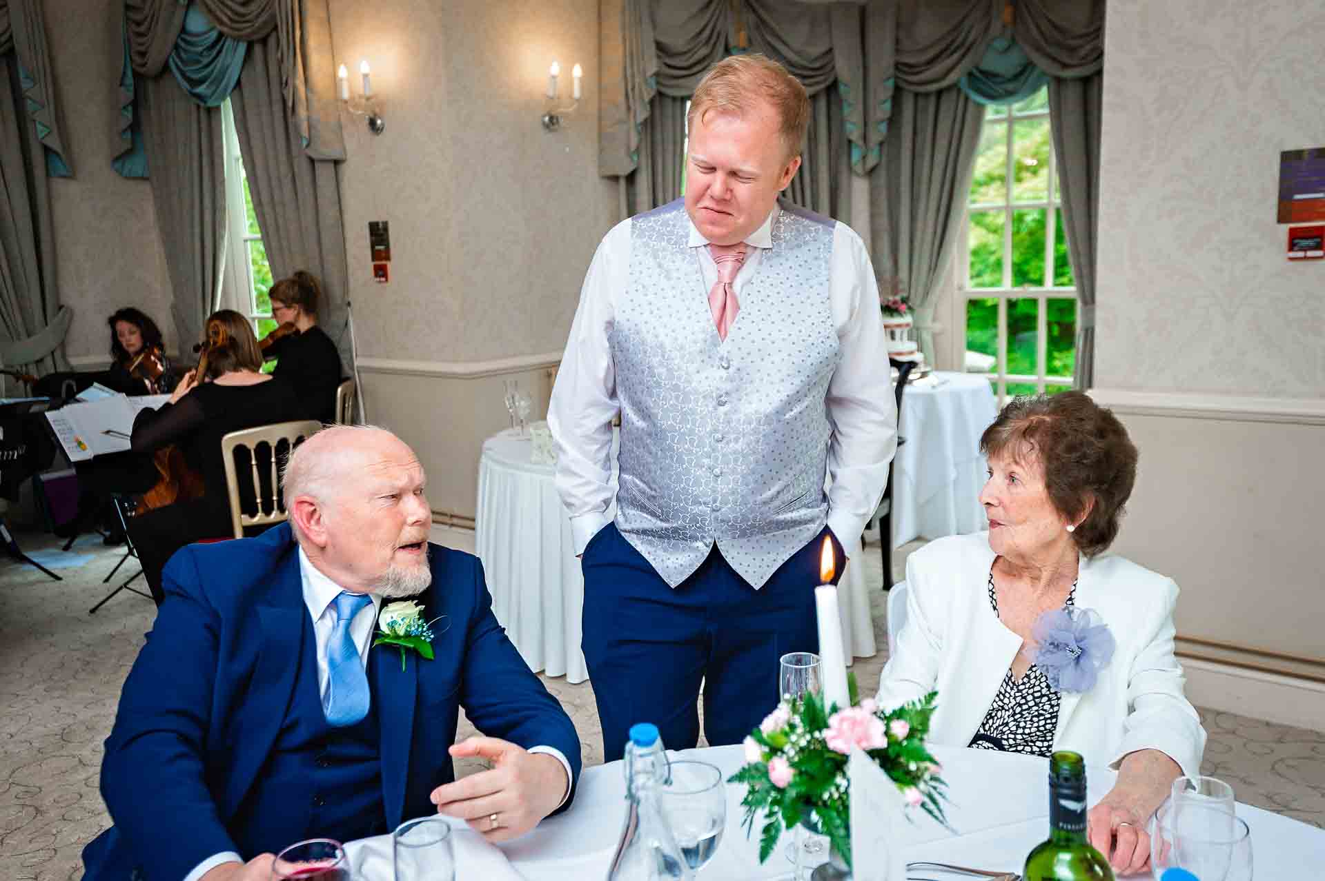 Groom talking to guests at wedding