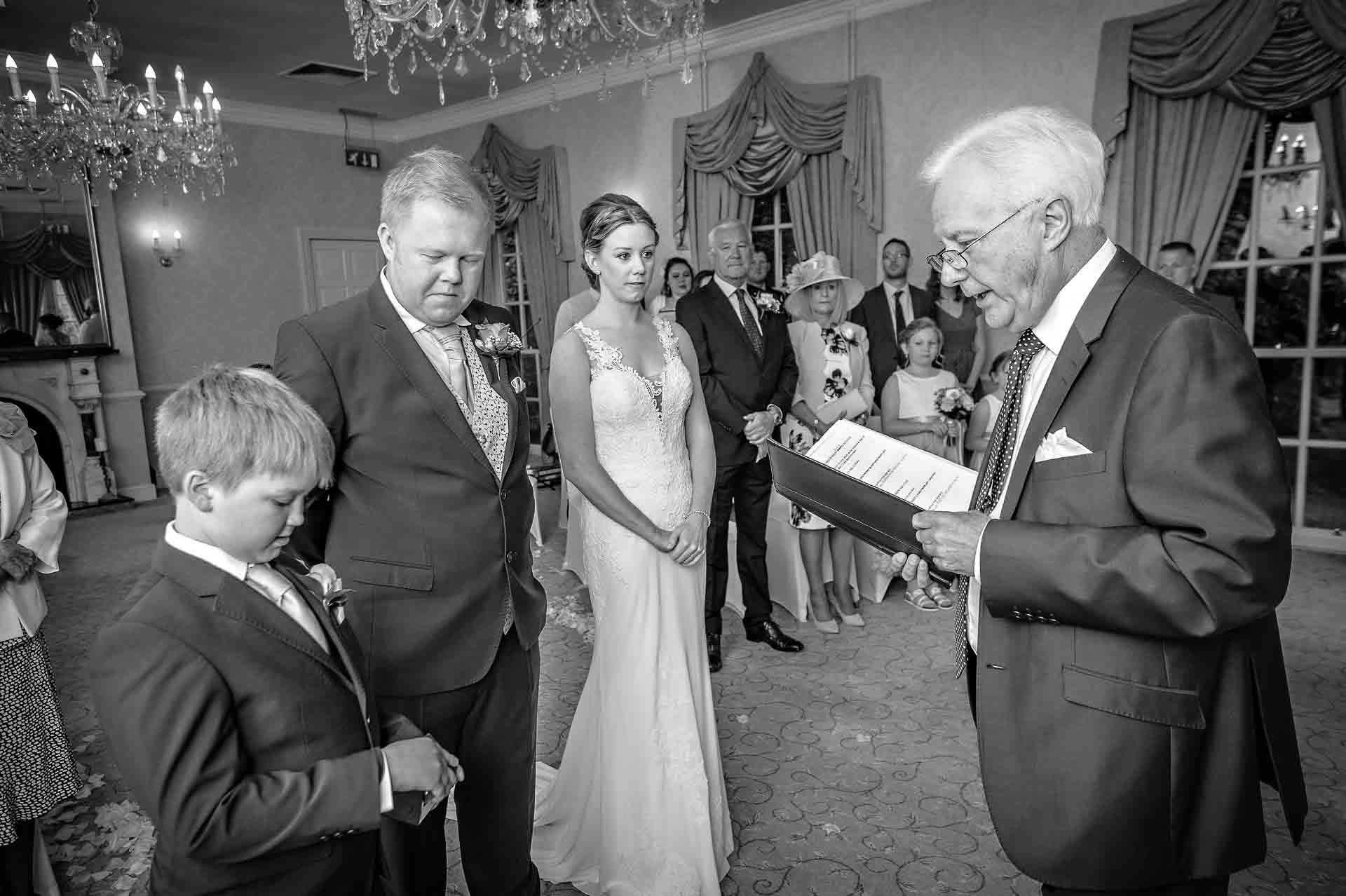 Page boy hands over rings at wedding