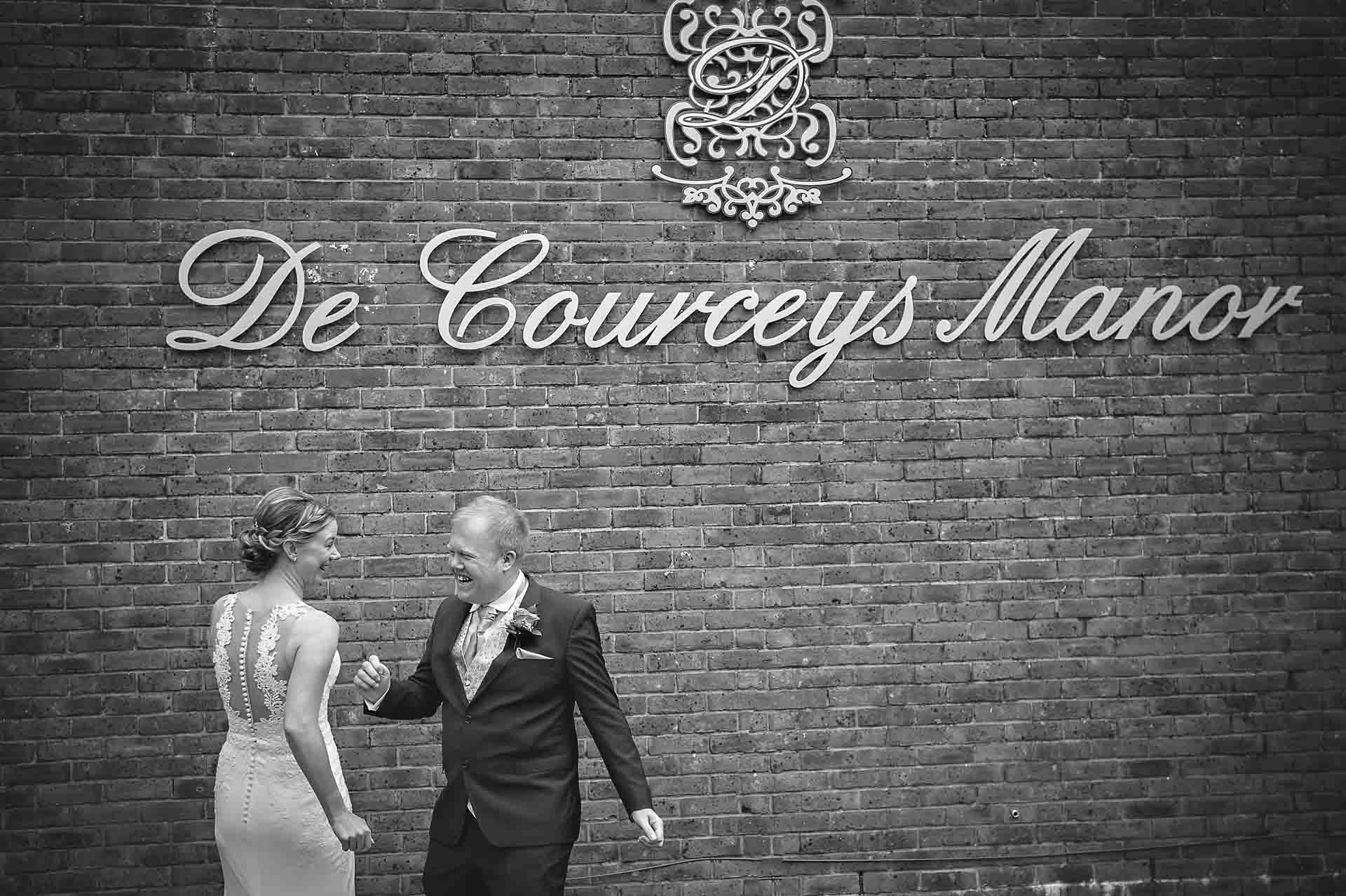 Bride and groom dancing under DeCourceys Manor venue sign