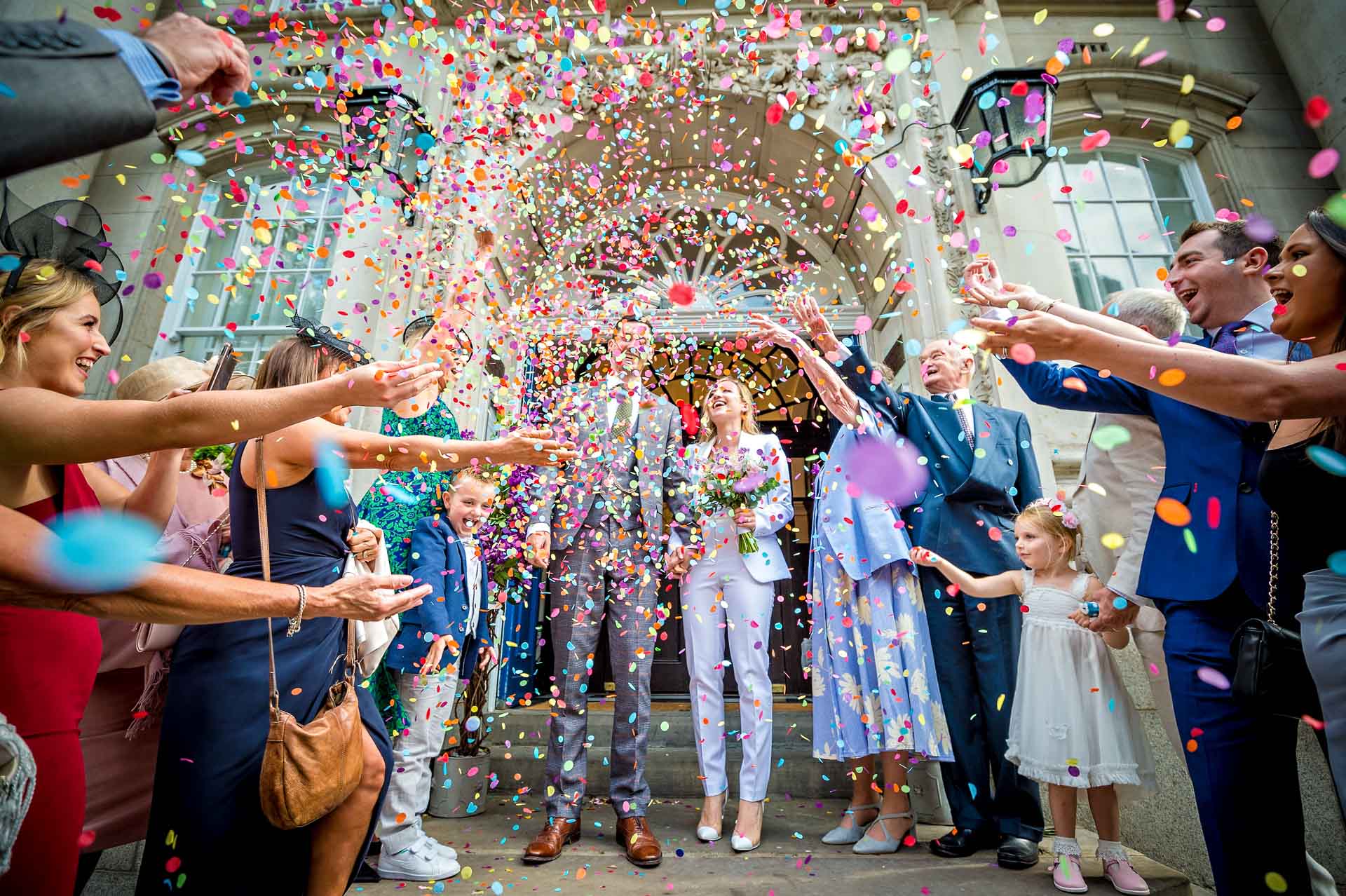 Extreme confetti storm over couple on steps on Chelsea Old Town Hall