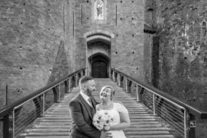 Newly married couple posing in front of Castell Coch near Cardiff