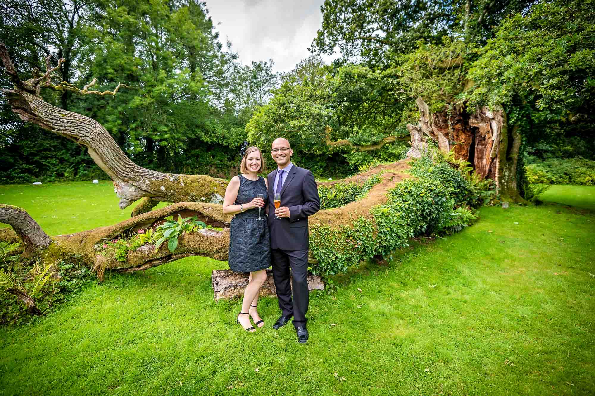 Happy guests pose in front of fallen tree at Plas Glansevin in Wales