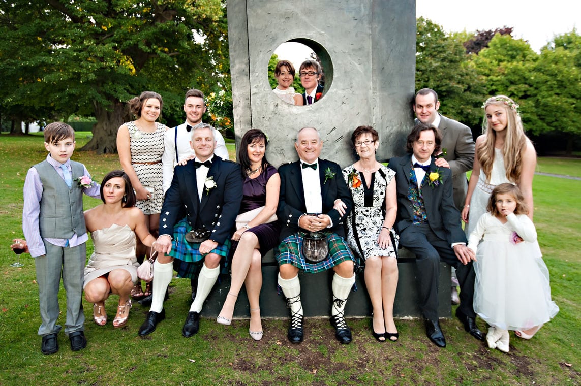 Family wedding group photo in front of sculpture