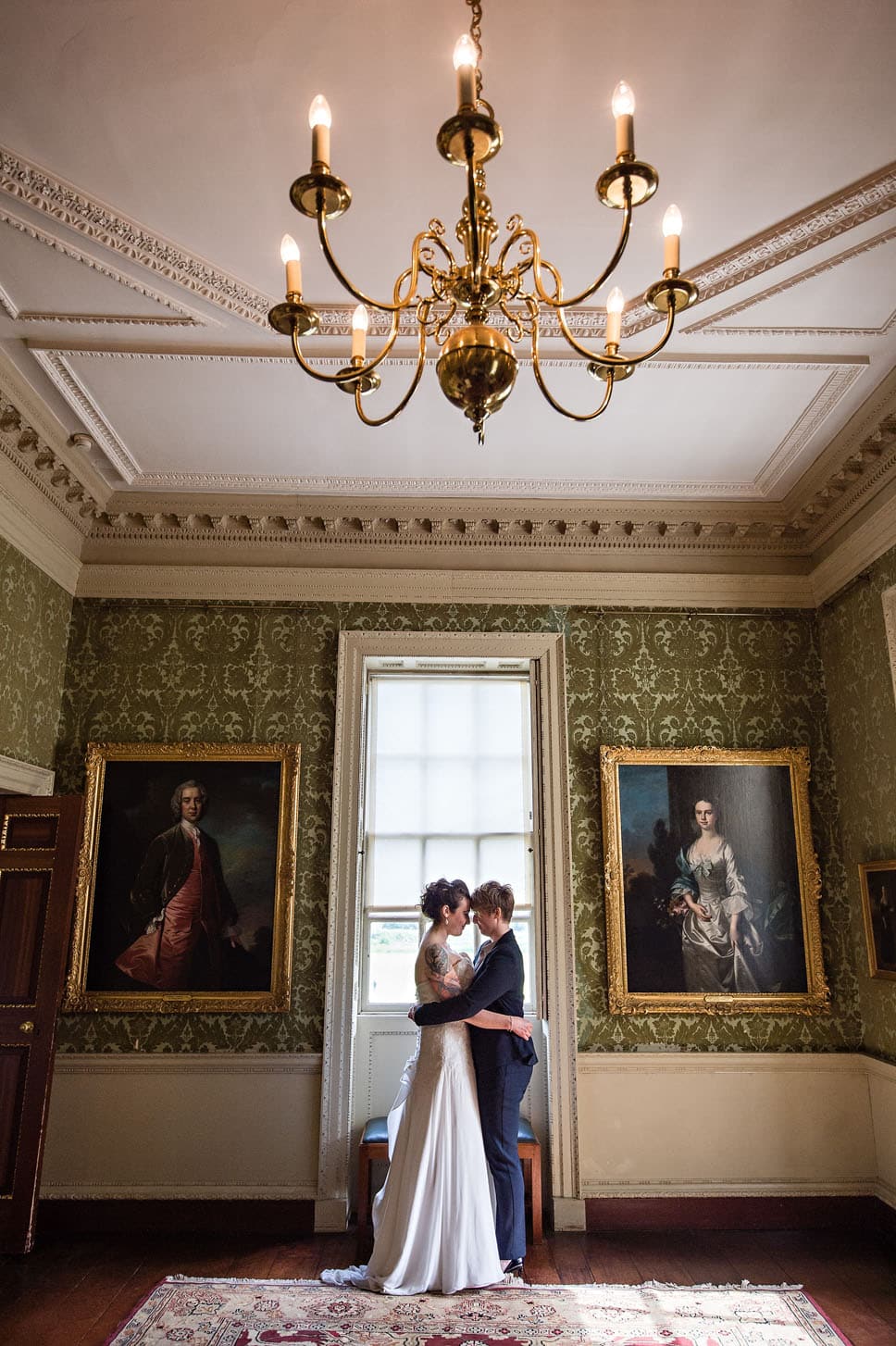 Female LGBT Couple in Stately Home Wedding Portrait Holding Each Other 