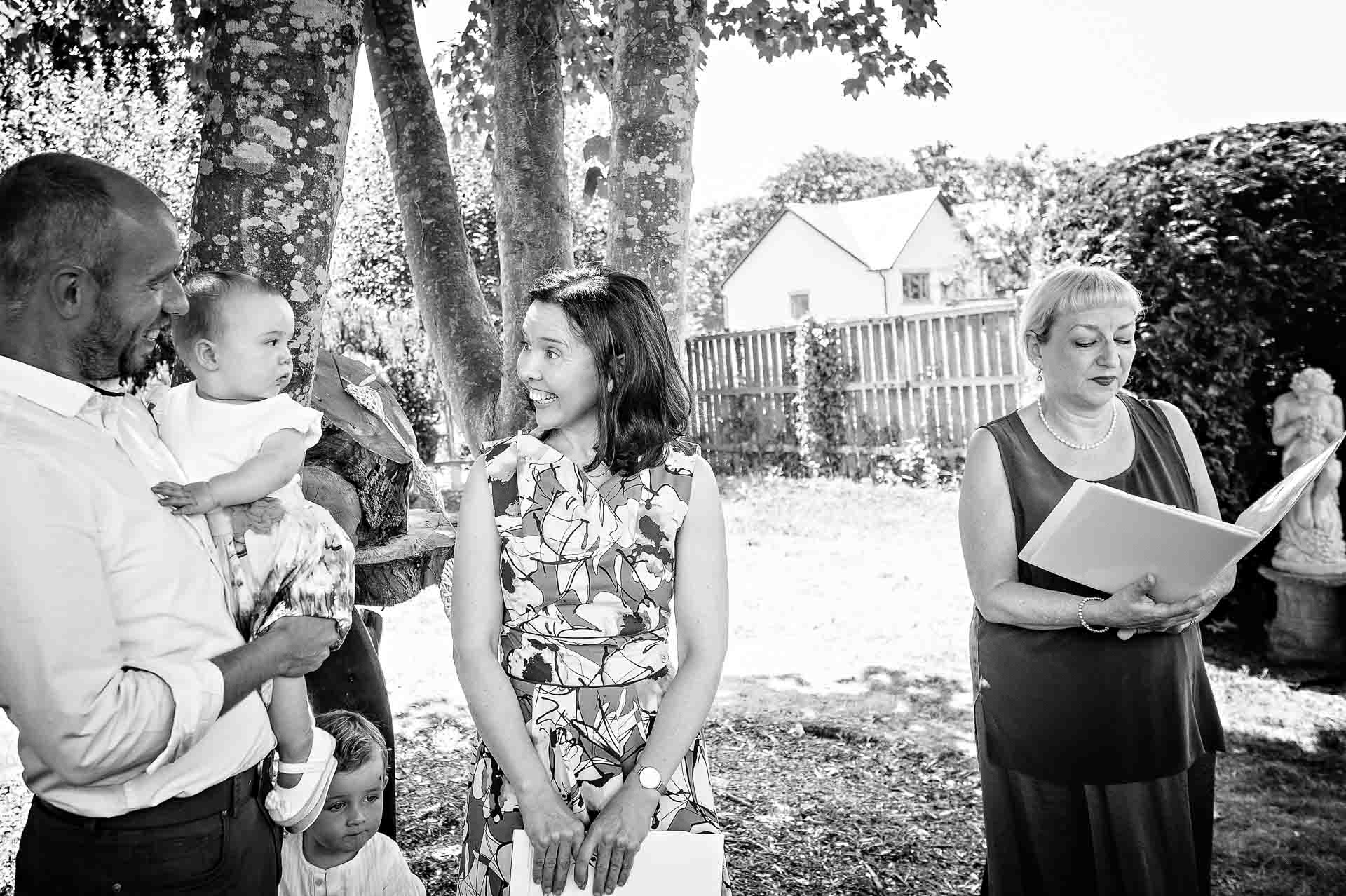 Humanist celebrant reading at baby naming with parents looking at baby girl