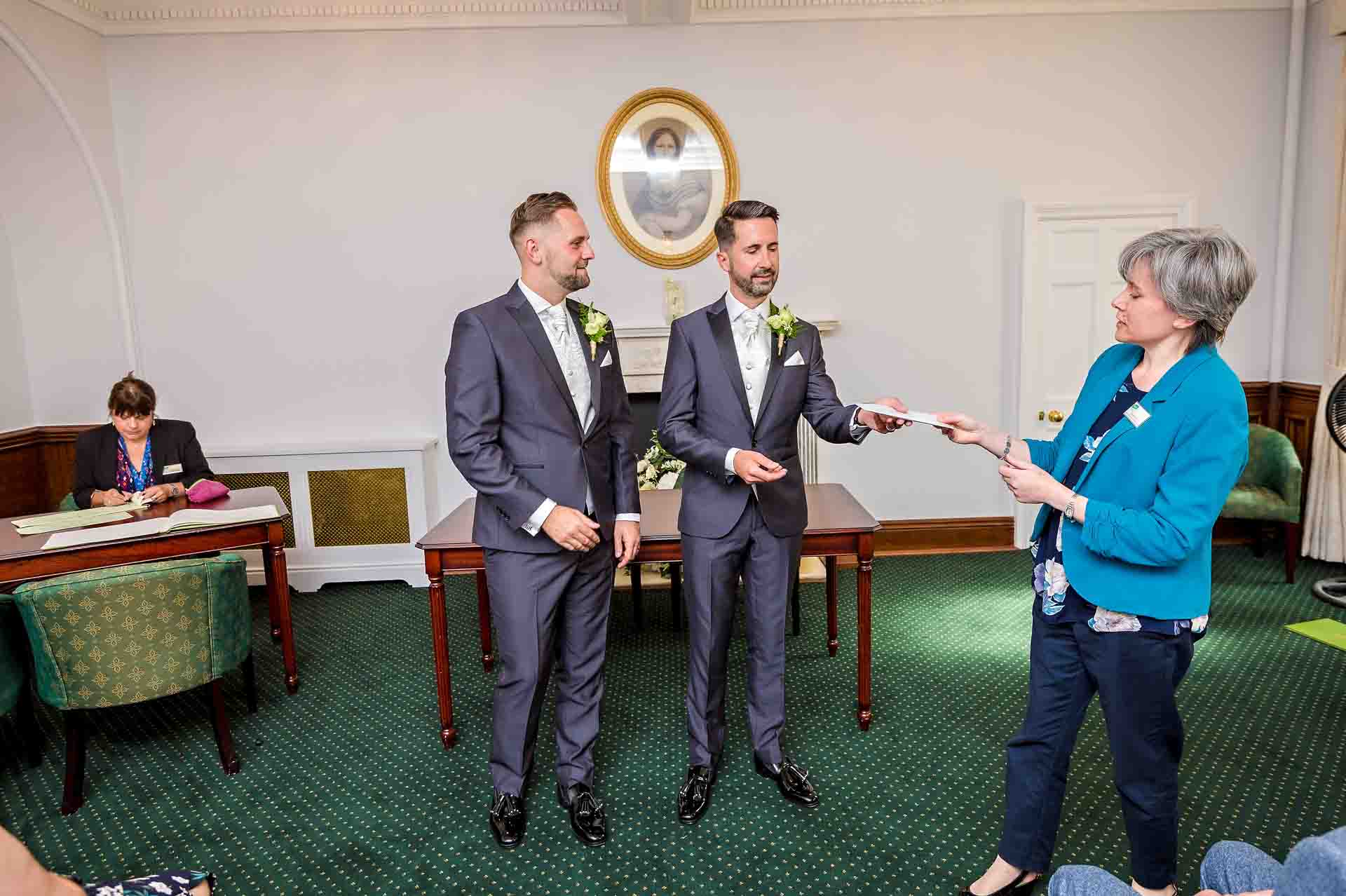 Registrar presenting certificate to couple at register office wedding