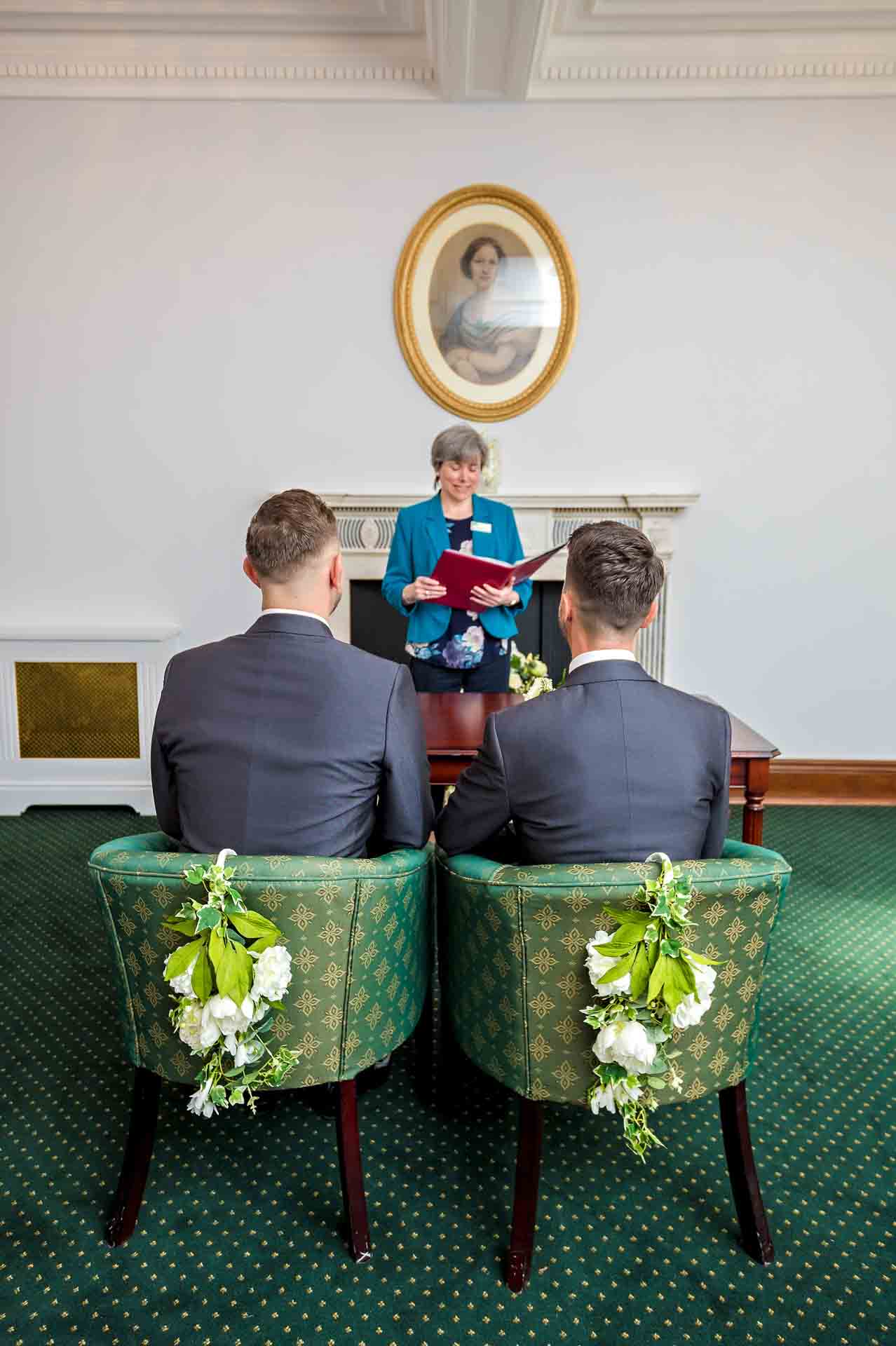 Grooms seated at their wedding ceremony from the back