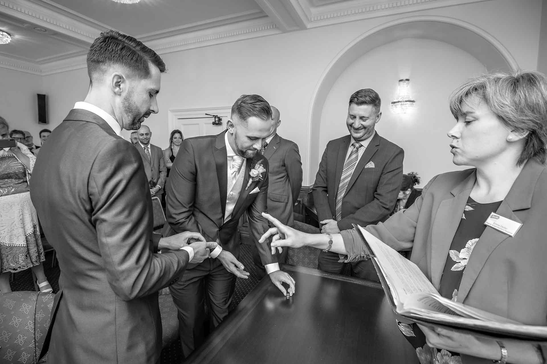 Registrar gesturing at groom just before exchange of rings at wedding in Kent