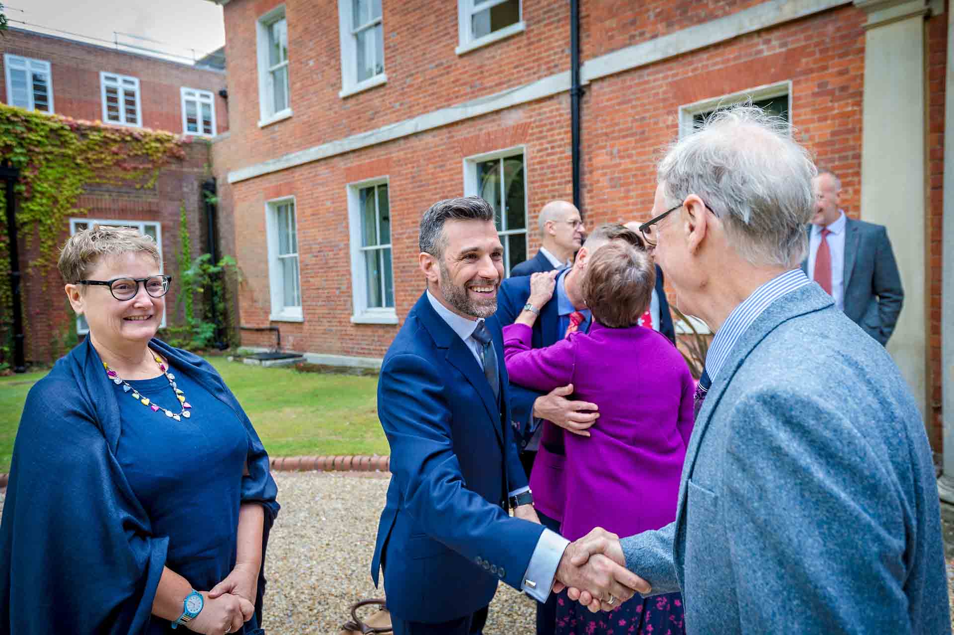 Guests shaking hands and smiling at Bromley Register Office wedding