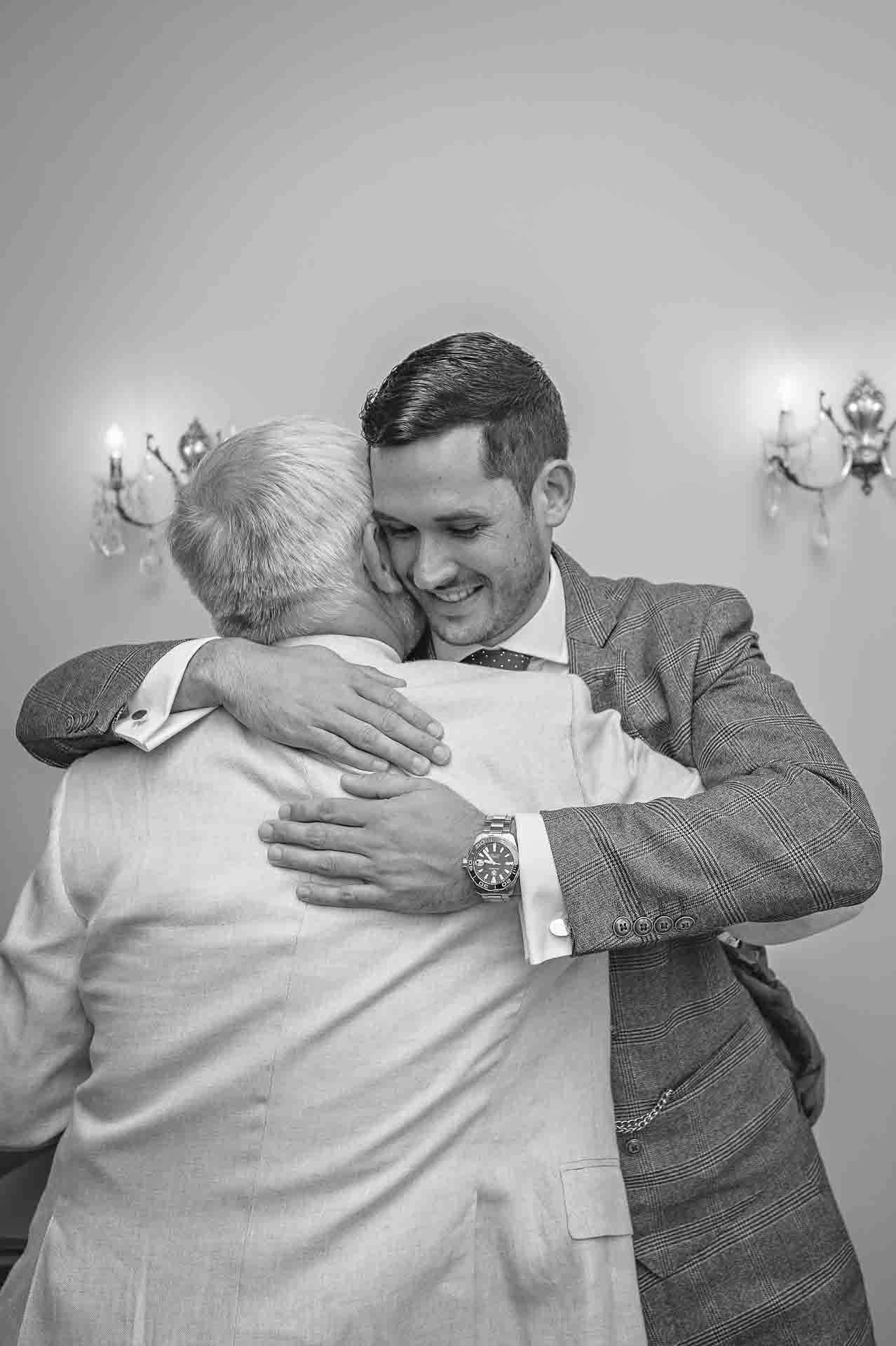 Groom hugs father at wedding in London